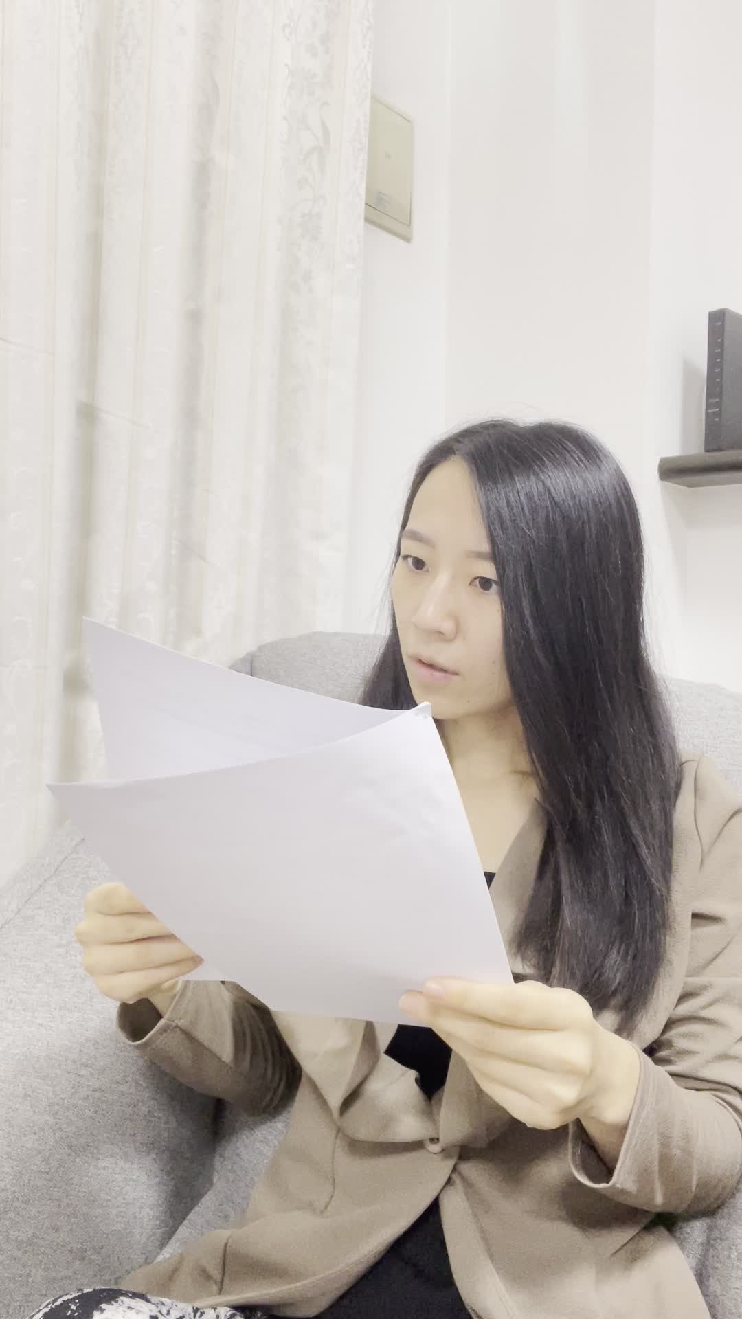 ソファで書類を整理しながら、「これが必要な情報」と安心した表情を浮かべる姿