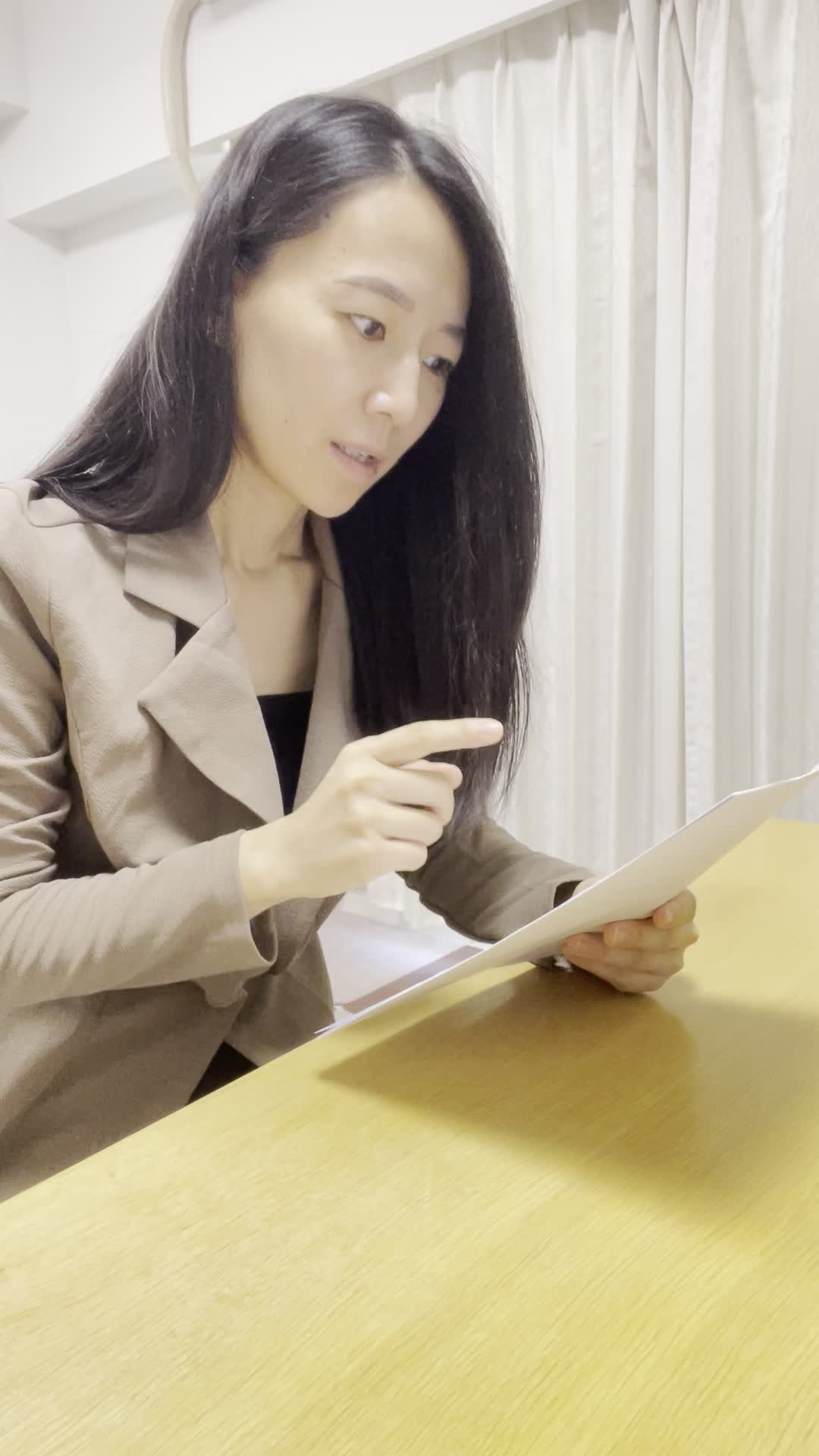 テーブルで契約書を確認し、「これで次に進める」とホッとした表情を浮かべる動作