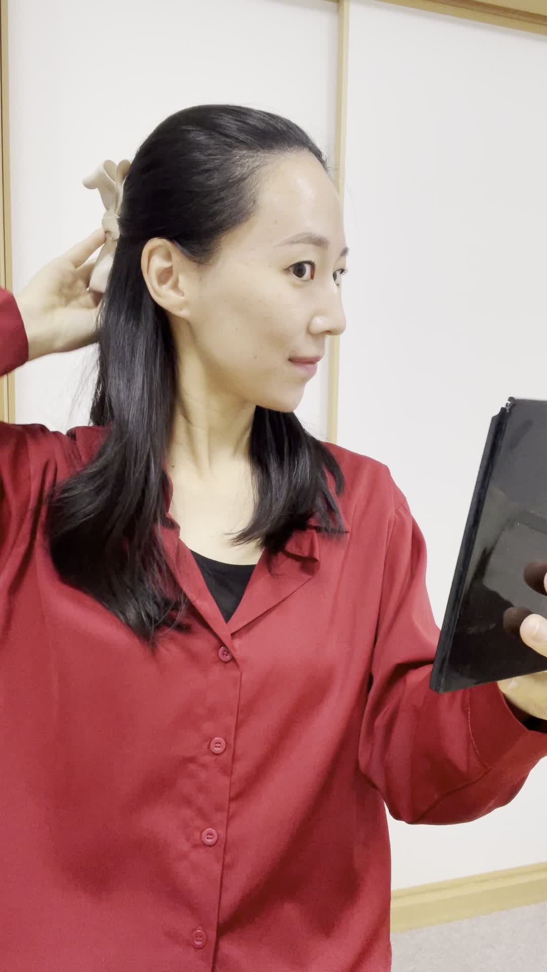 鏡の前で髪をまとめ直し、「明日はこれで出かけよう」と微笑む仕草