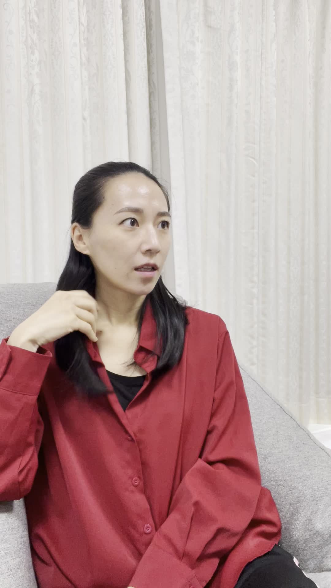 ソファで友達に髪のパサつきを指摘され、軽く傷ついた表情を浮かべる様子