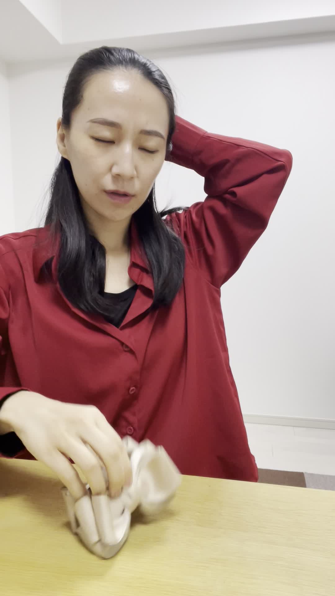 テーブルで仕事の合間に髪を束ね直し、「これじゃ全然収まらない」と悩む様子