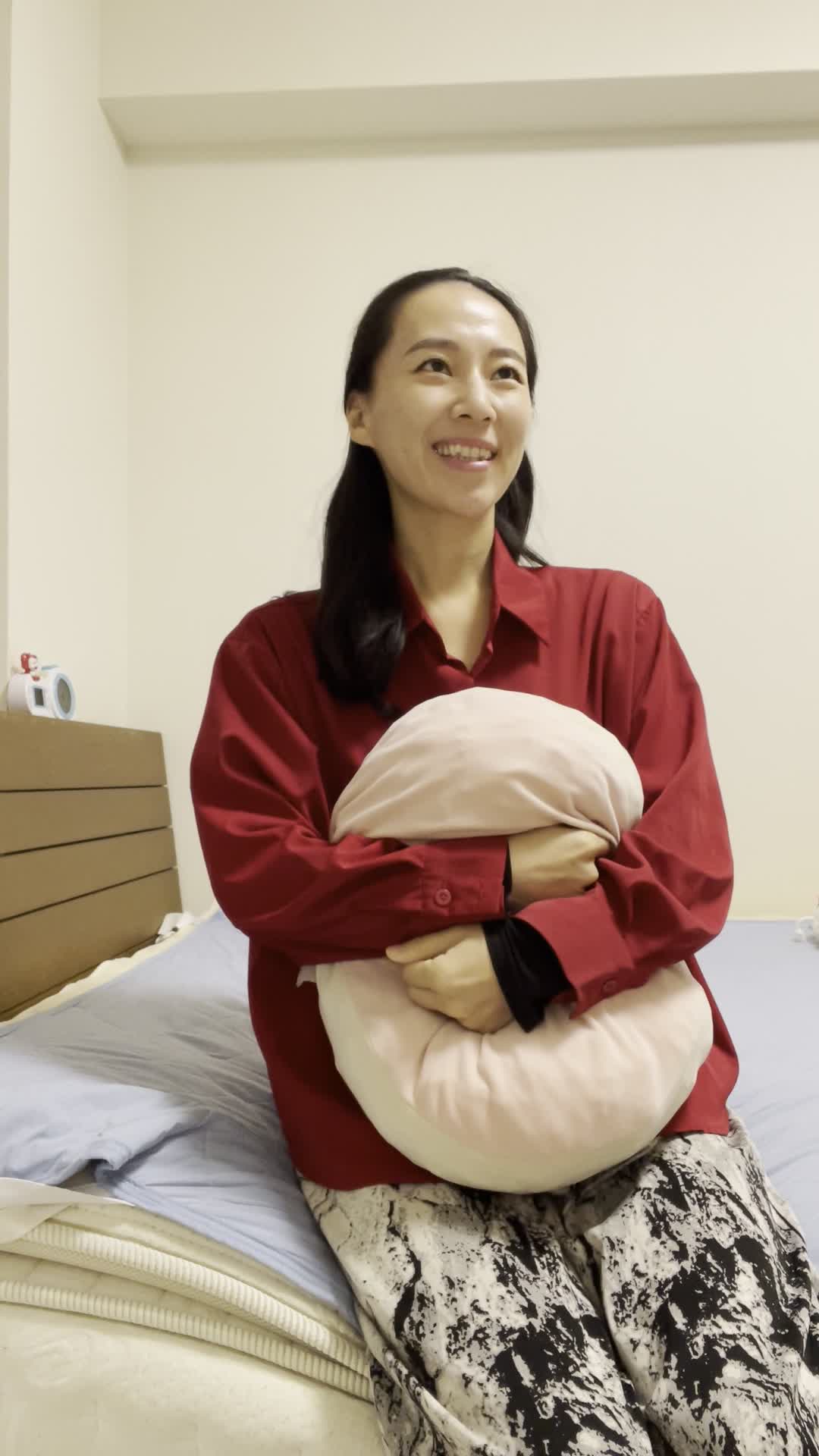 ベッドでクッションを抱きしめ、「髪がまとまったらどんな気分だろう」と期待に胸を膨らませる姿