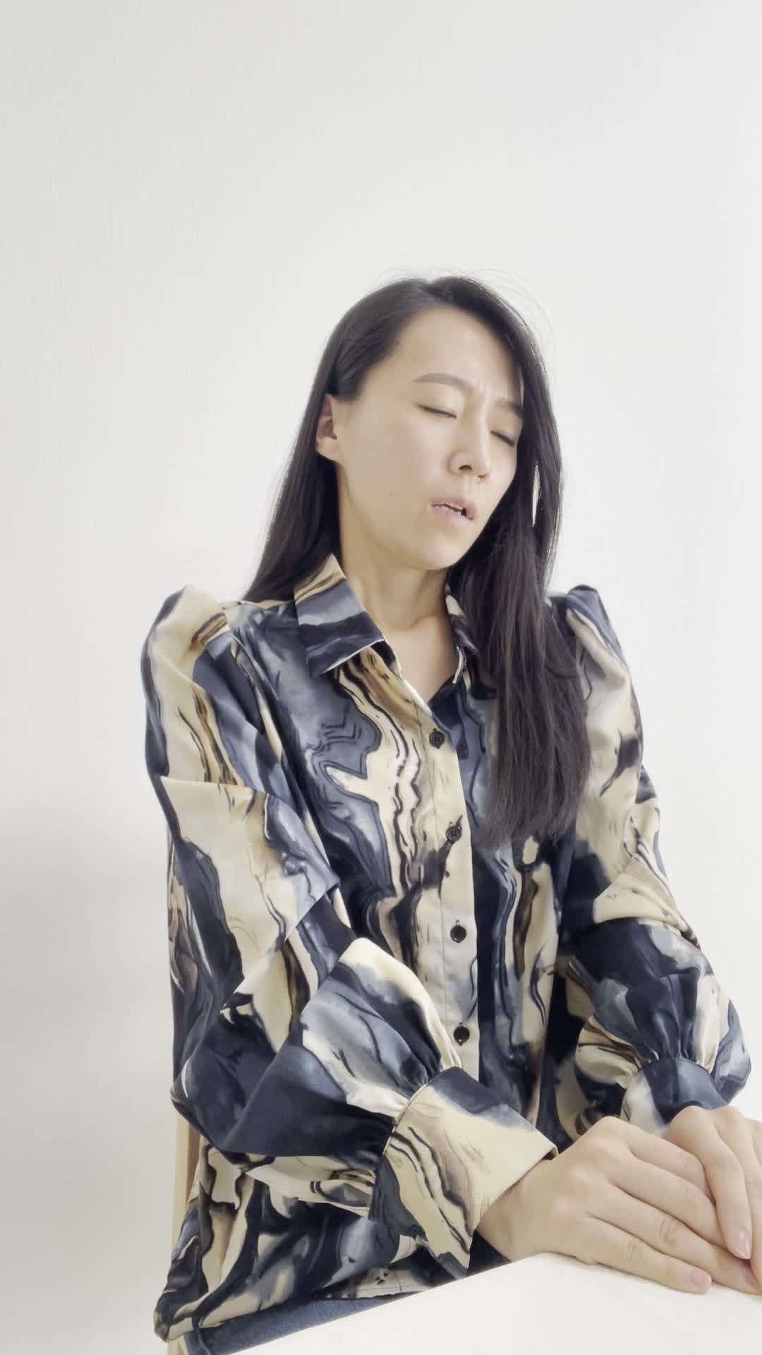 椅子に浅く腰掛け、水を取りに立ち上がるのが面倒そうな表情を見せる仕草