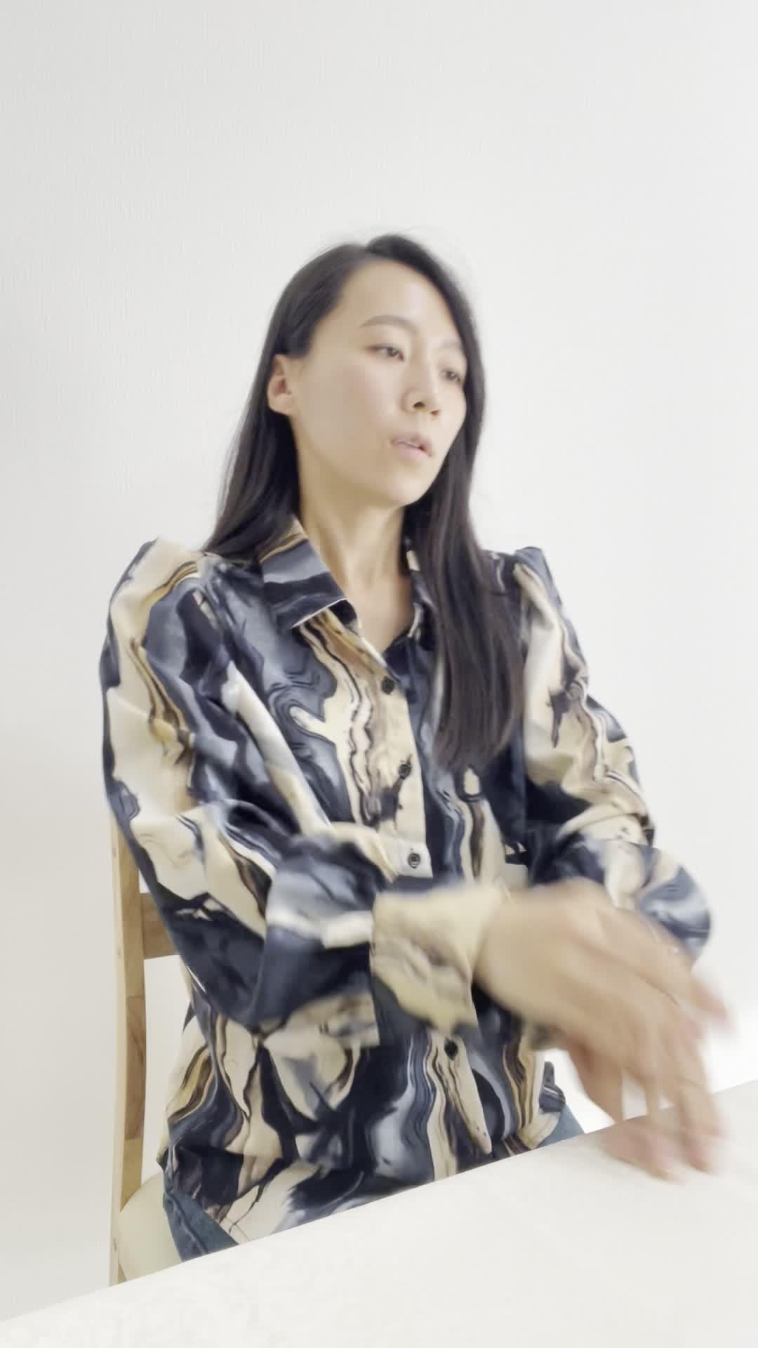 椅子に座り直して、「ウォーターサーバーがあれば外で買わなくて済むのに」と考える表情