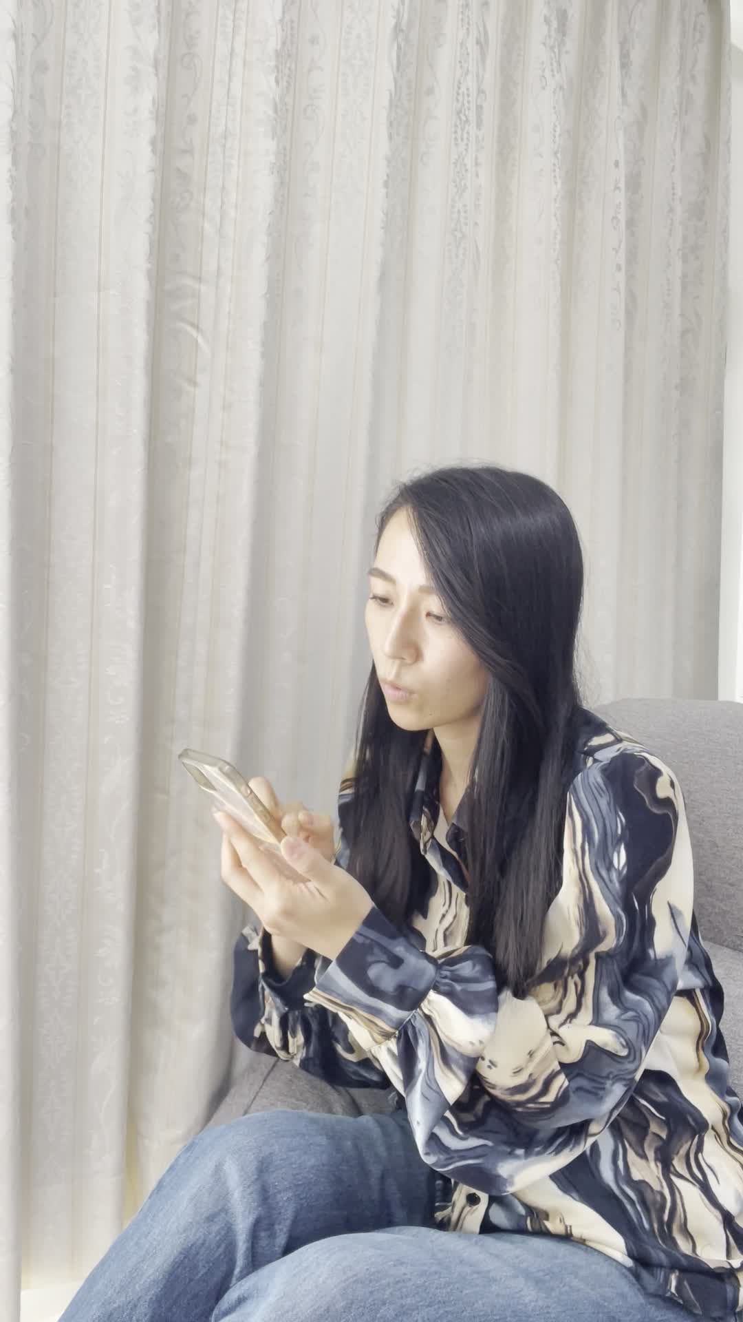 ソファでスマホを見ながら、「ウォーターサーバーってどうなんだろう？」と検索する様子