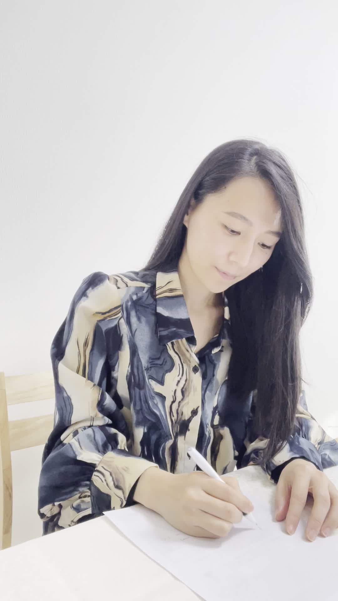 テーブルで紙にプランを比較して、「これならコスパもいいかも」と頷く動作