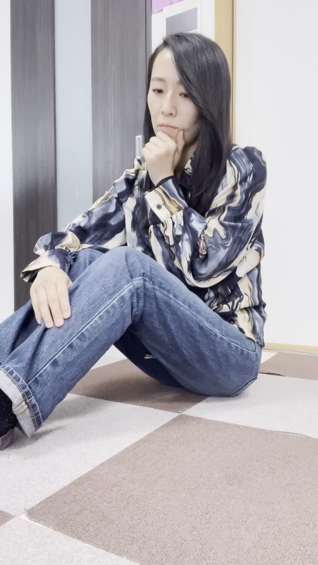 床に膝を立てて座り、「これ以上重たい水を運ぶのは大変」と考え込む動作