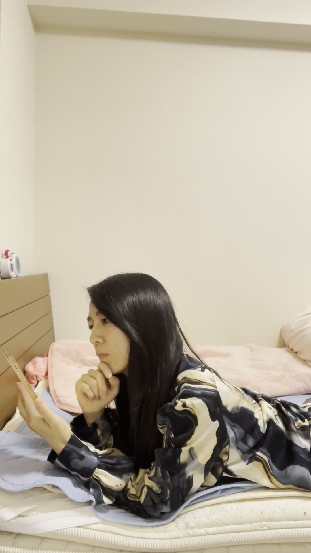 ベッドで脚を伸ばし、「冷たい水がすぐに飲めたら…」とスマホで調べる姿