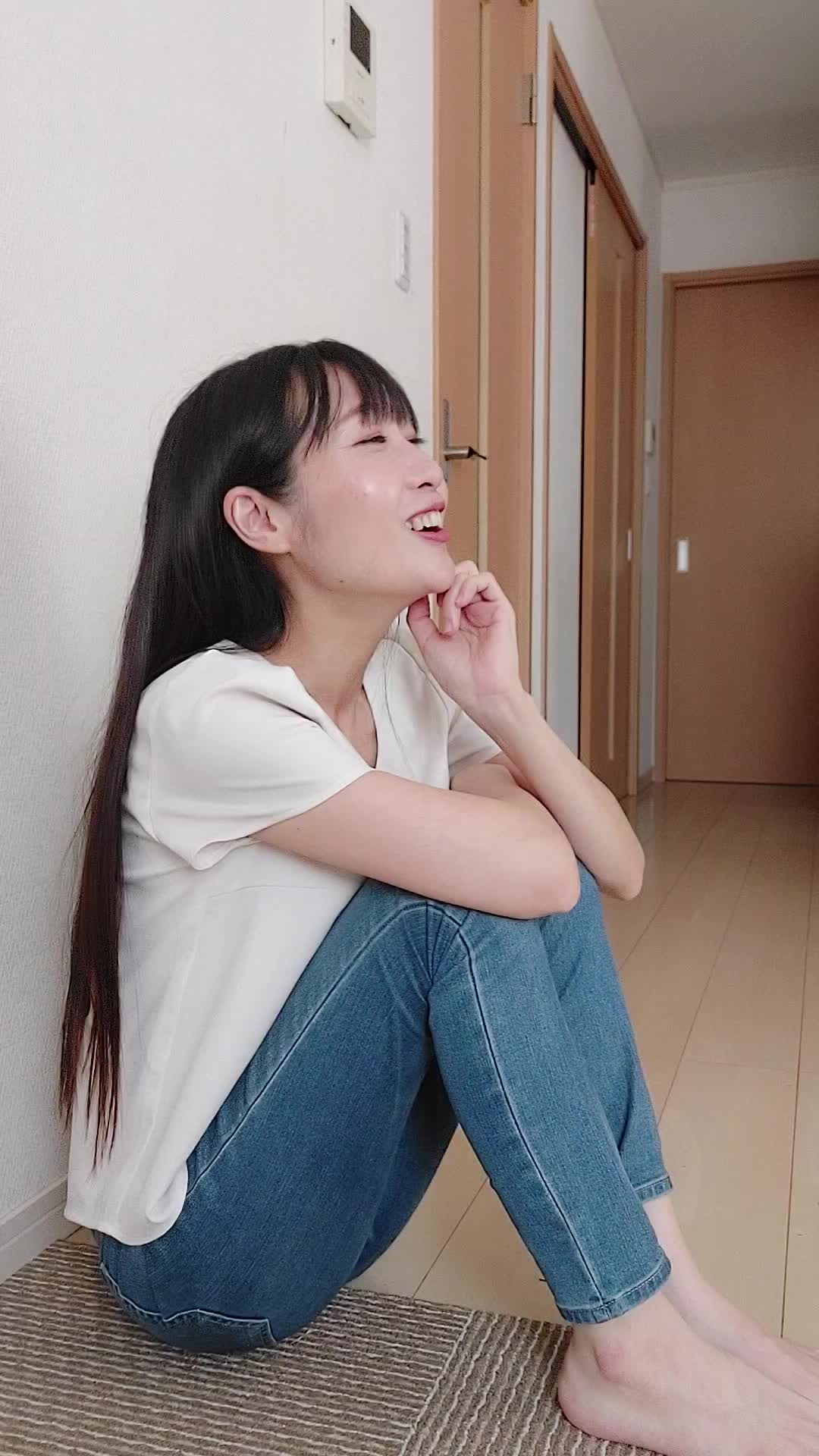 床で膝を立てて座り、「体臭が気にならない生活がどんな感じか想像する」微笑む姿