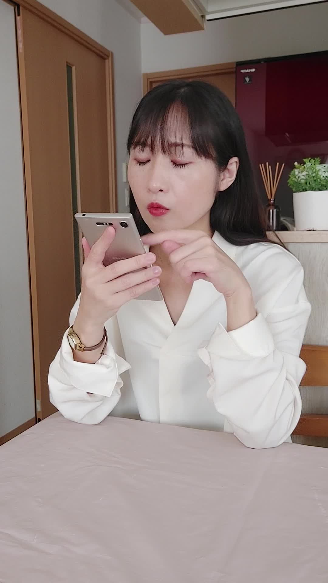椅子に座り、スマホで求人情報を眺めながら「どれが自分に合うだろう」と悩む表情