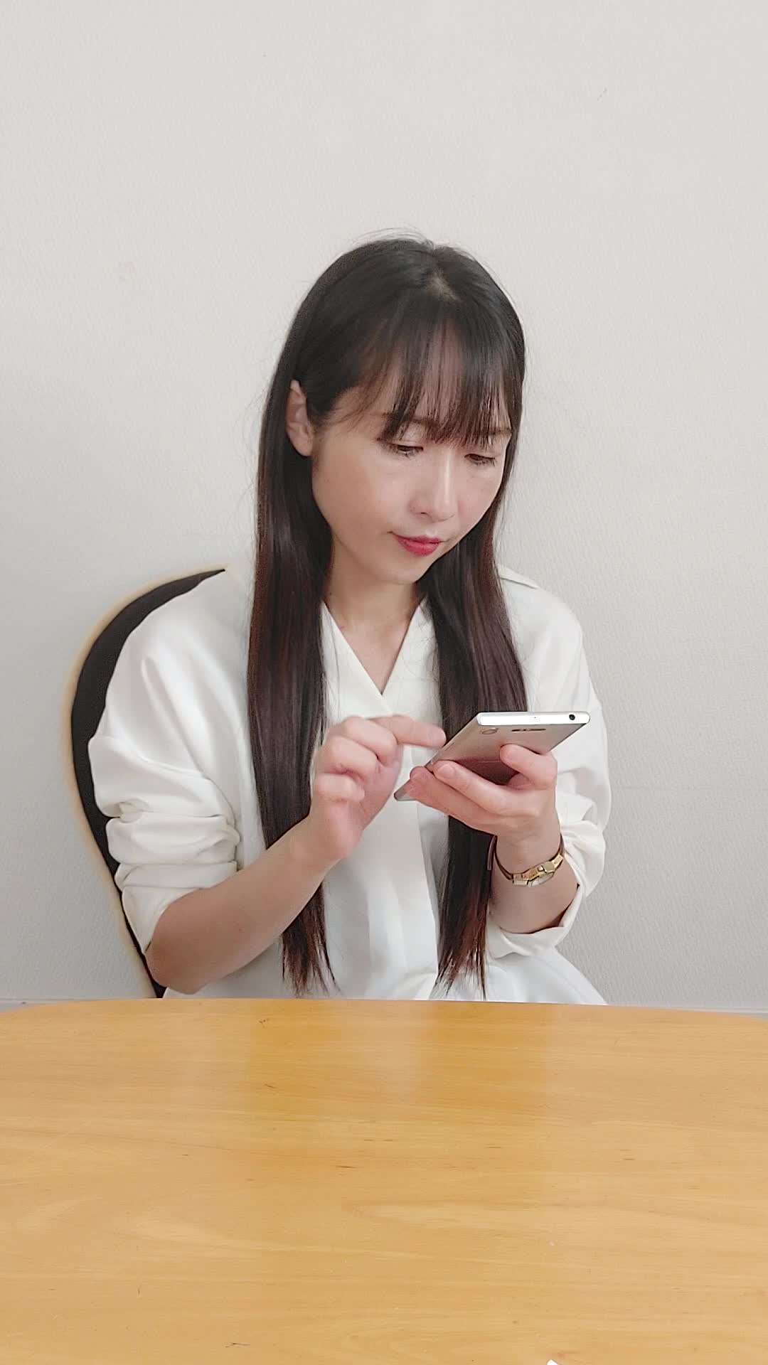 ソファでスマホを眺めながら、「応募結果を待ちながら少し緊張する」表情
