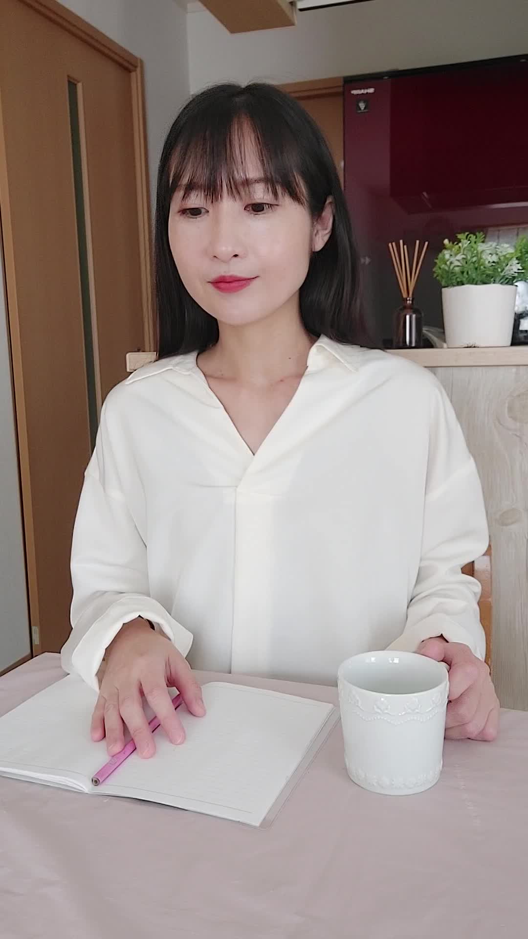 テーブルでカップを手に取り、「新しい仕事での生活を計画する」姿