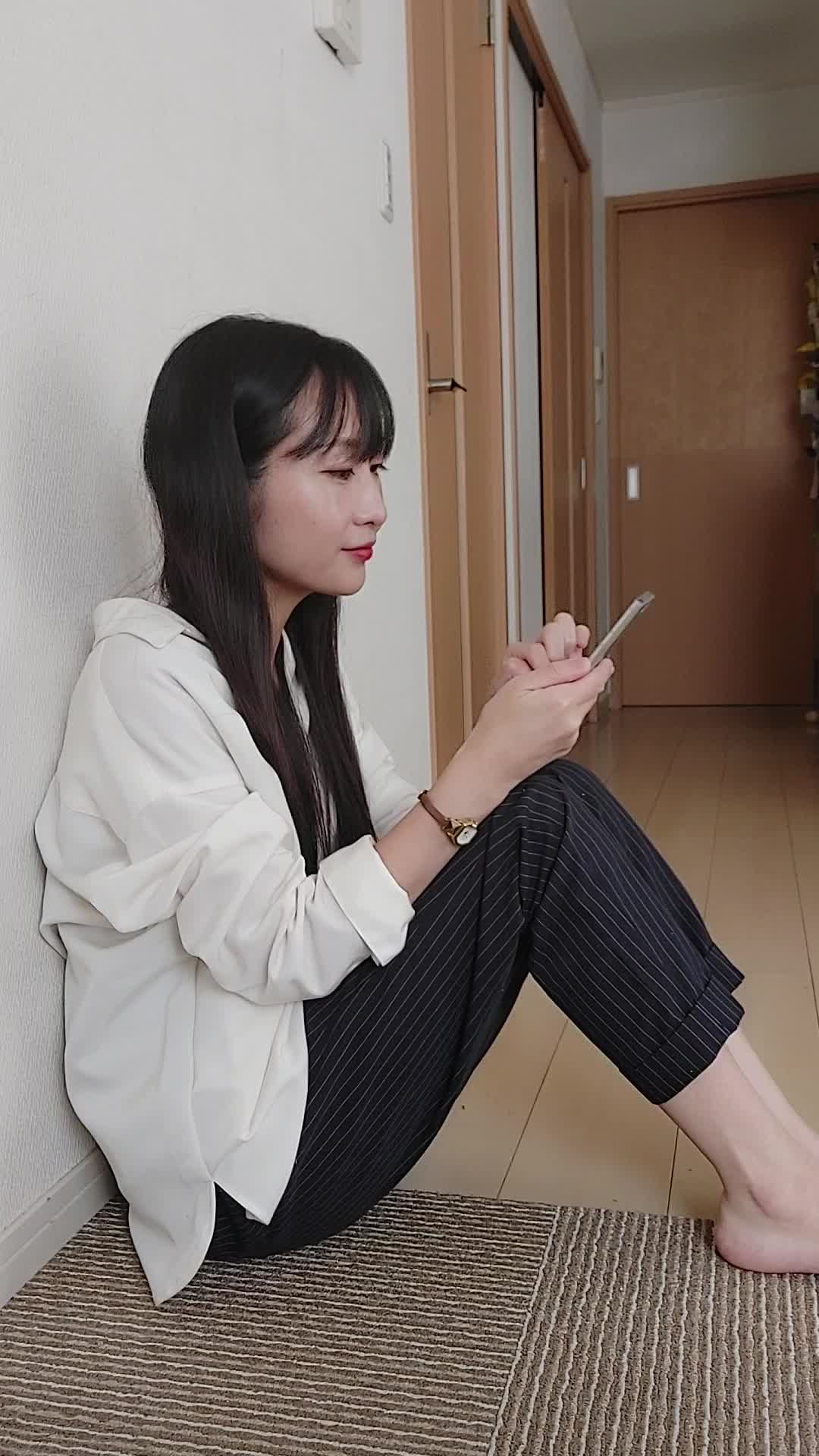 床に座り込み、「これなら挑戦できるかも」とスマホの画面を見て微笑む姿