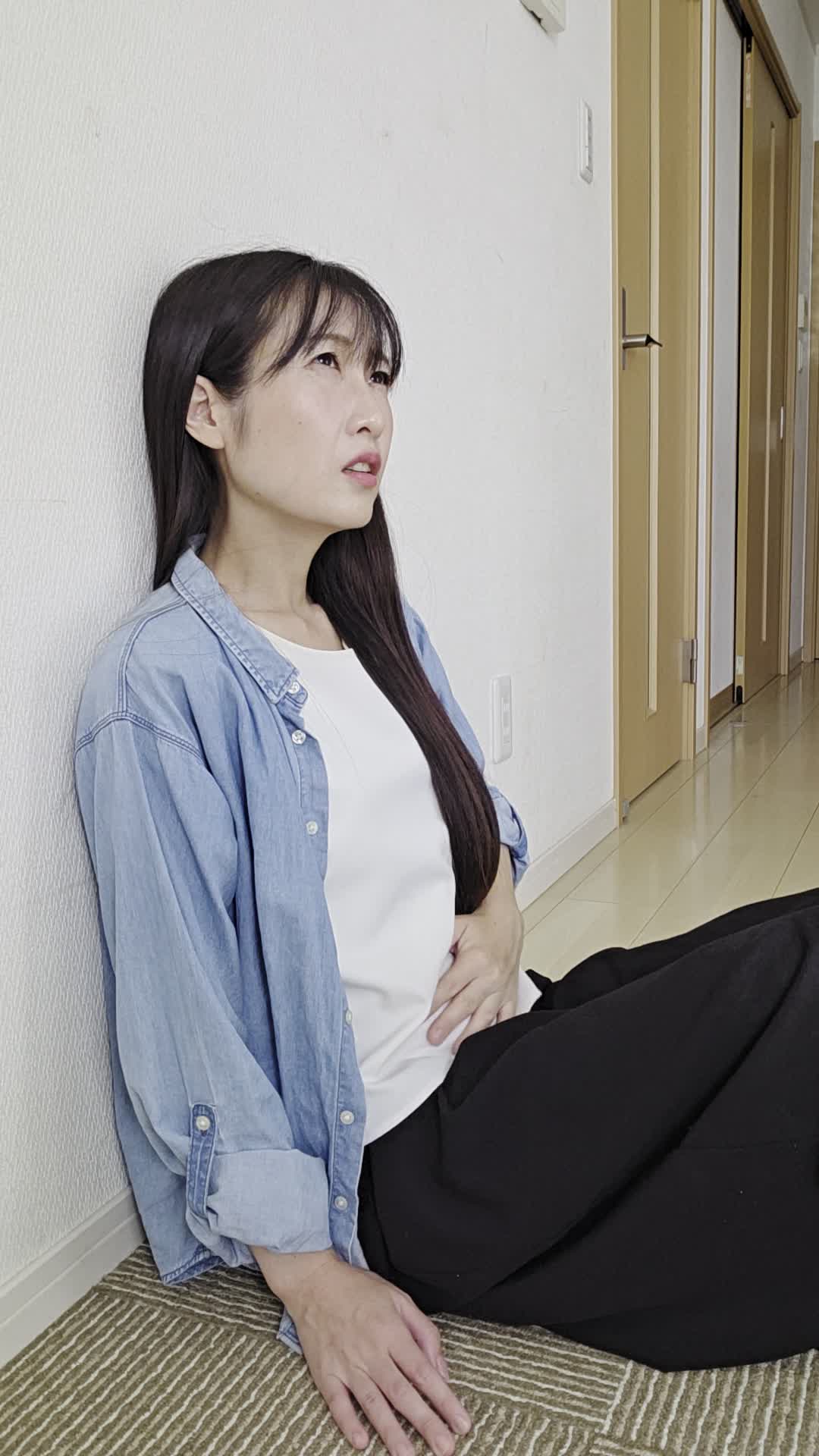 床に座り込み、「お腹が張っていてスッキリしない」とため息をつく姿