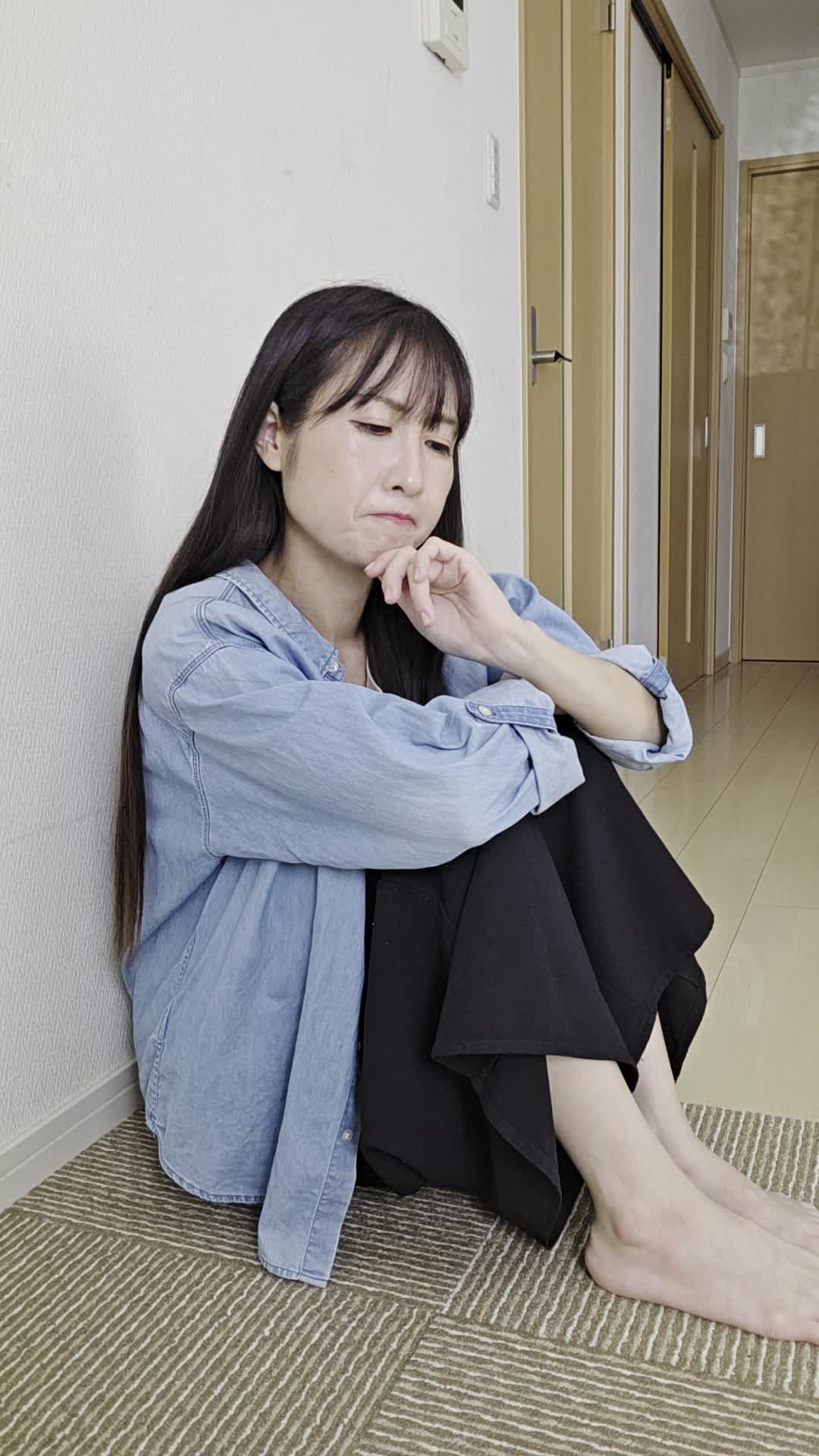 床に膝を抱えて、「なぜこんなに体が重いのか」と考え込む真剣な姿