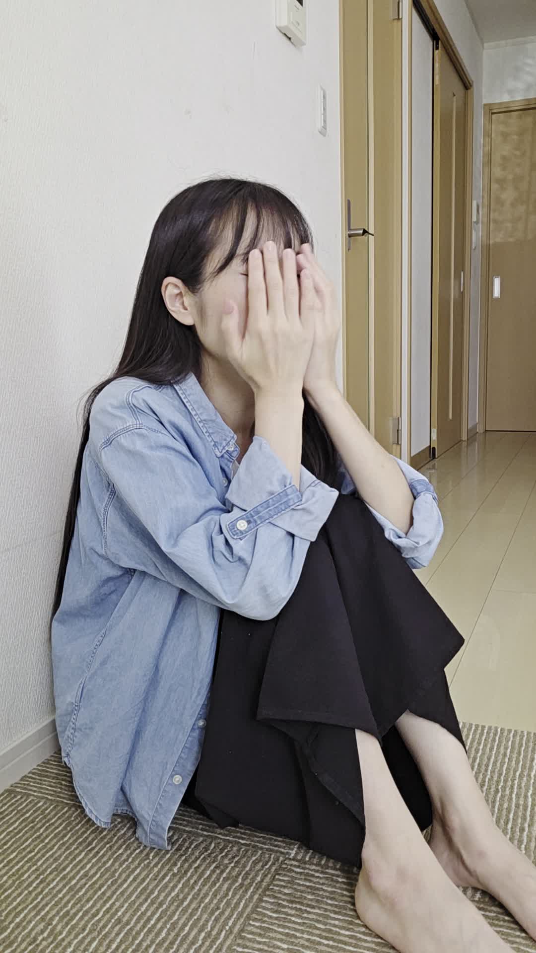 床で顔を両手で覆い、「腸の不調が続くせいで疲れが取れない」と落ち込む表情