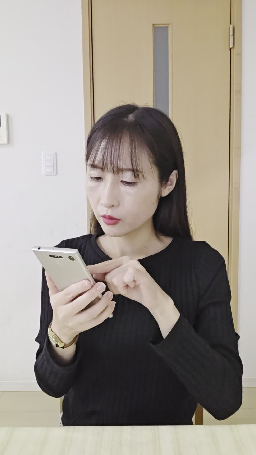 テーブルでスマホを見ながら、「体調を整える方法を必死に検索する」真剣な表情