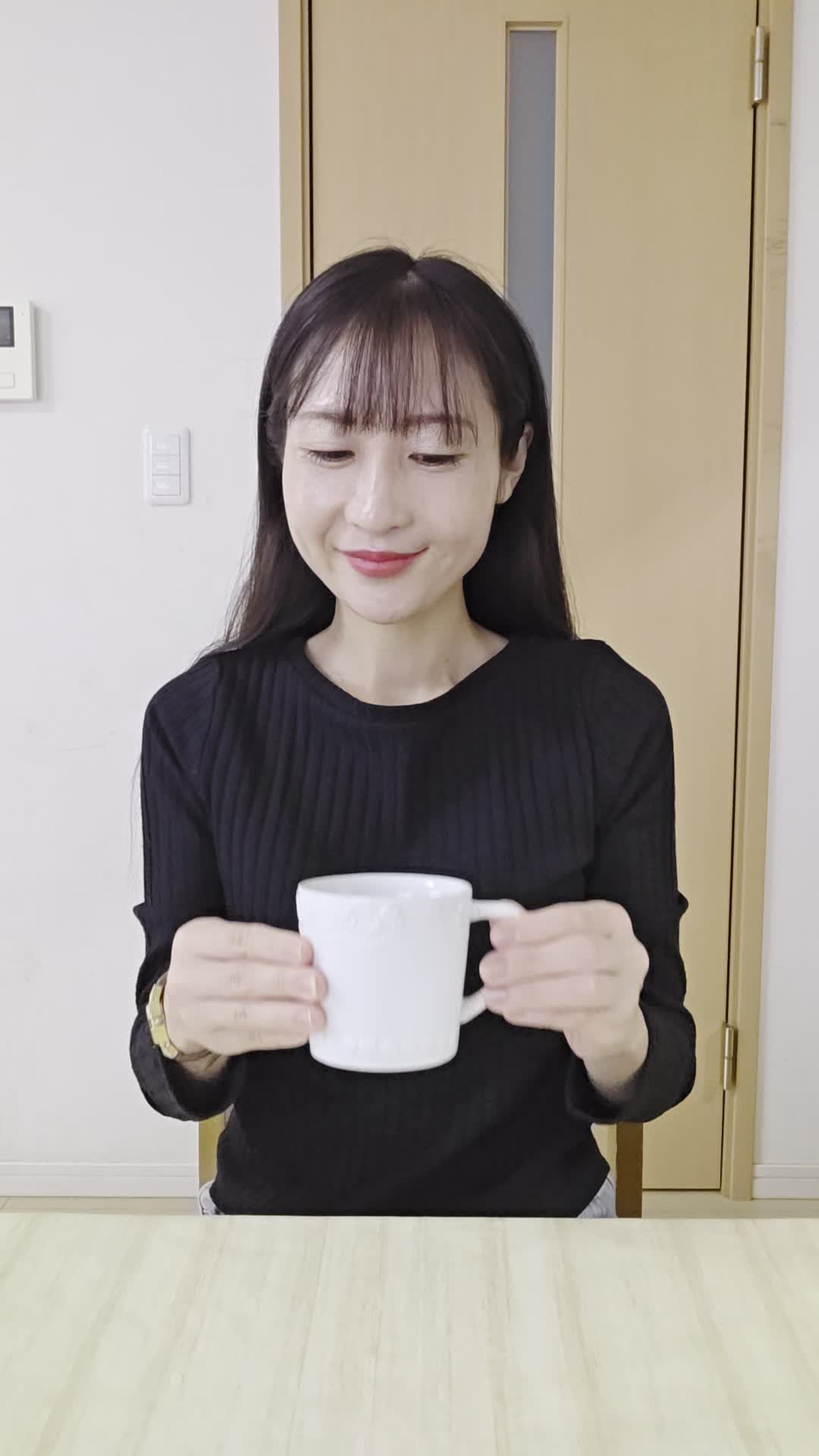 テーブルで飲み物を手に取り、「これで改善するなら試したい」と期待する微笑み