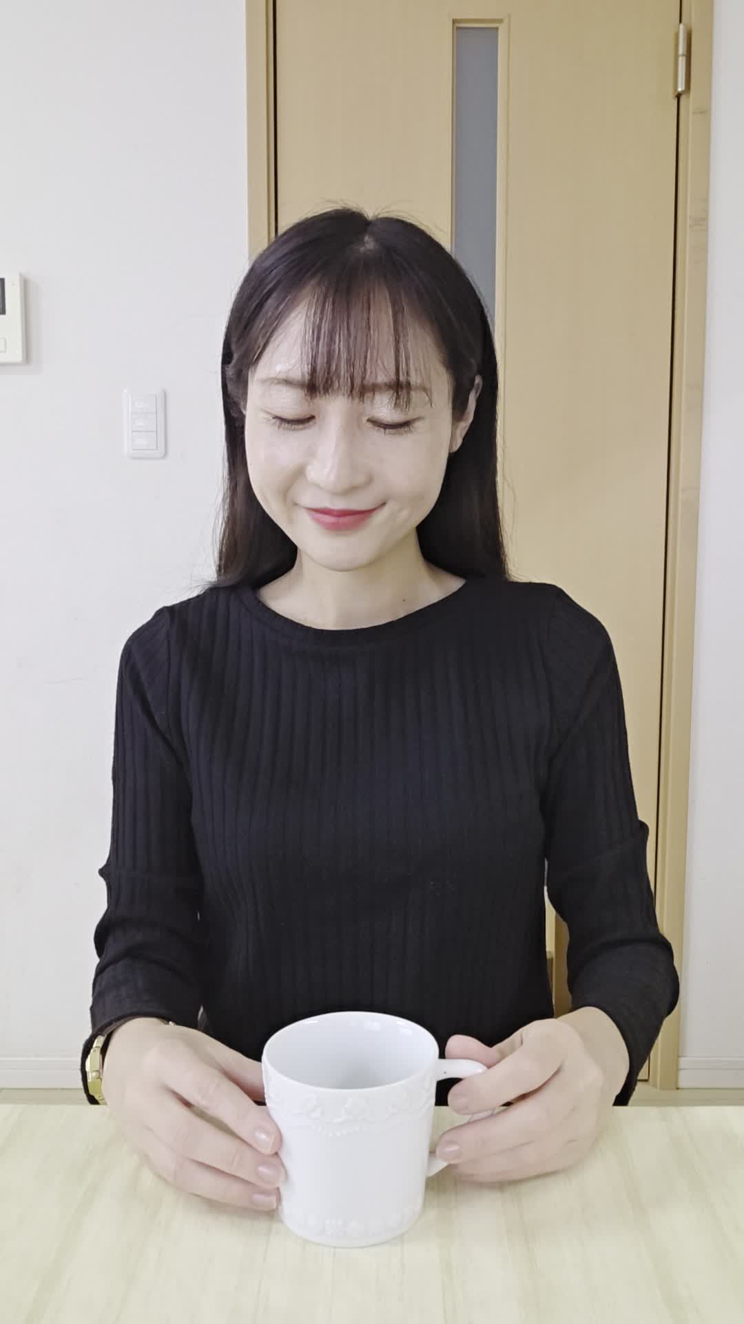 テーブルでカップを手に取り、「少しずつ体が良くなる期待を込めて飲み始める」微笑み