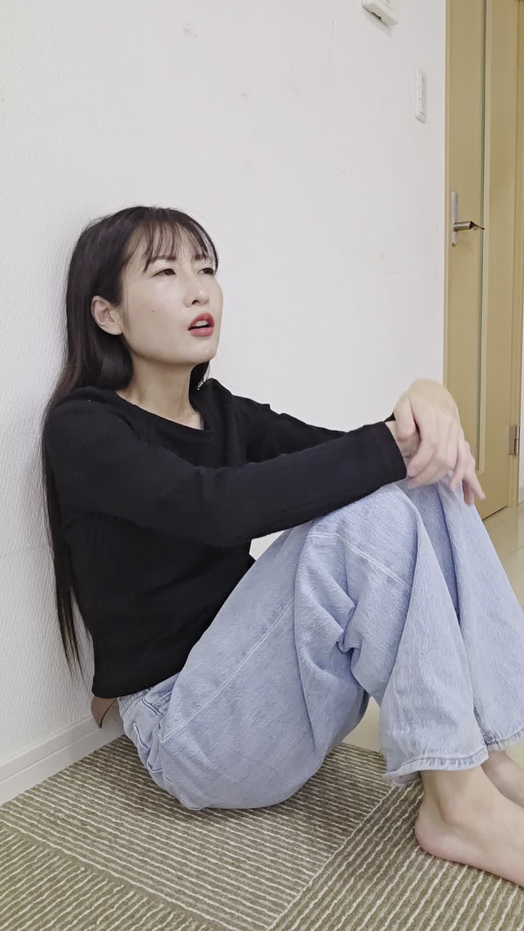 床に座り込み、「最近体が重くて動きが鈍い」と両手を膝に置いて考え込む姿