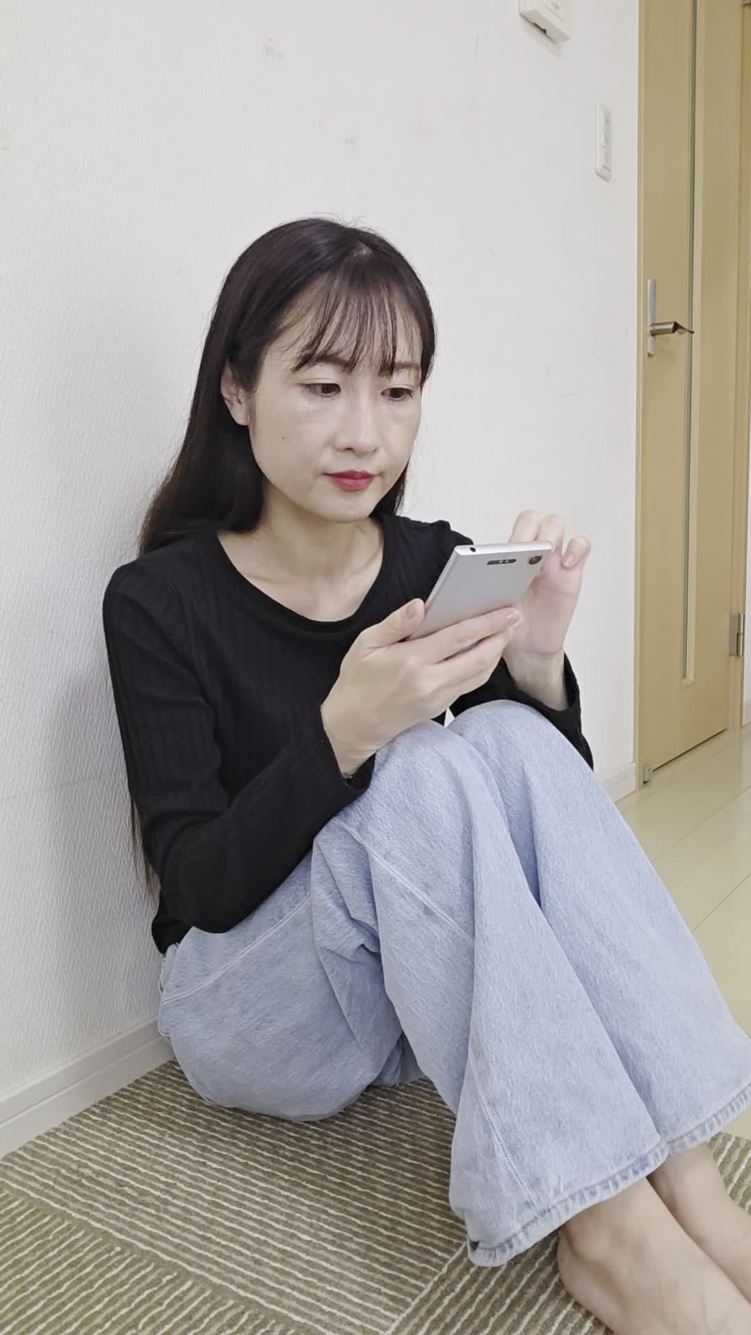 床でスマホを操作しながら、「健康ドリンクが自分に合うか調べている」真剣な姿