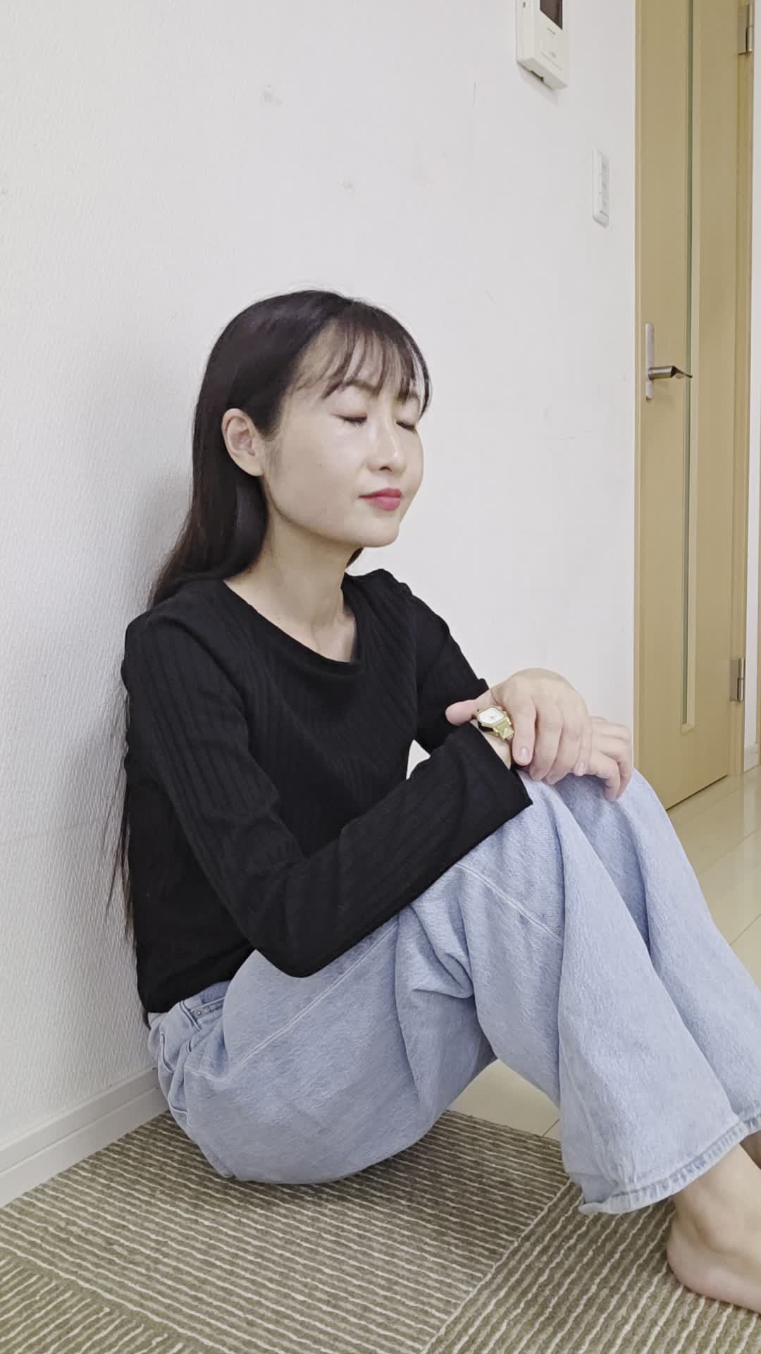 床で両手を膝に置き、「健康ドリンクで元気を取り戻したい」と決意を固める姿