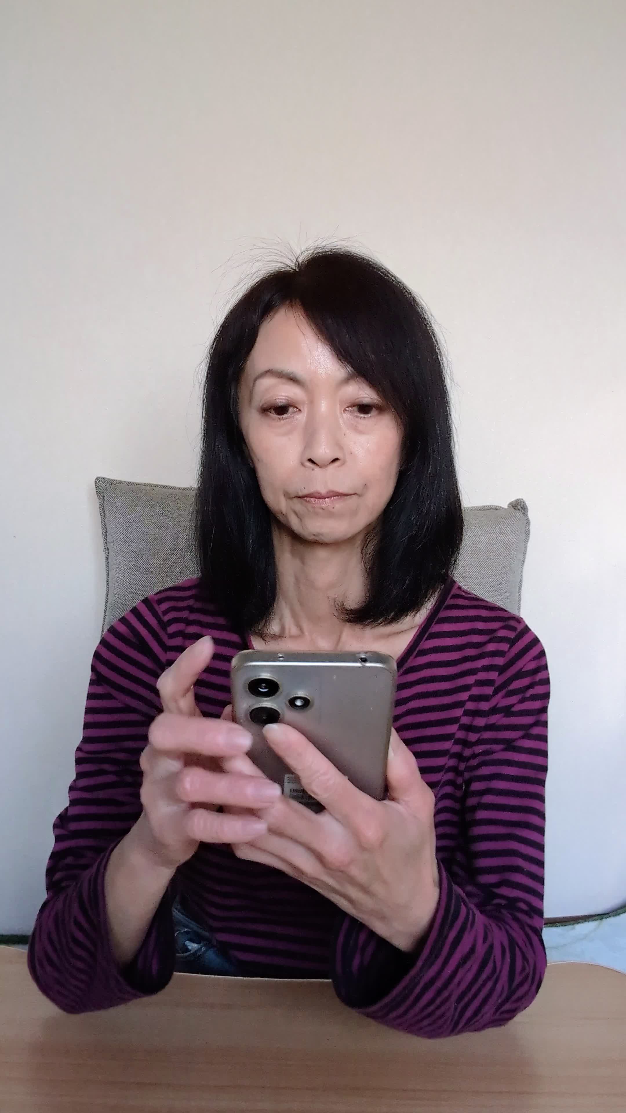 テーブルでスマホを操作しながら、「体臭ケアのおすすめ商品を調べる」集中した様子