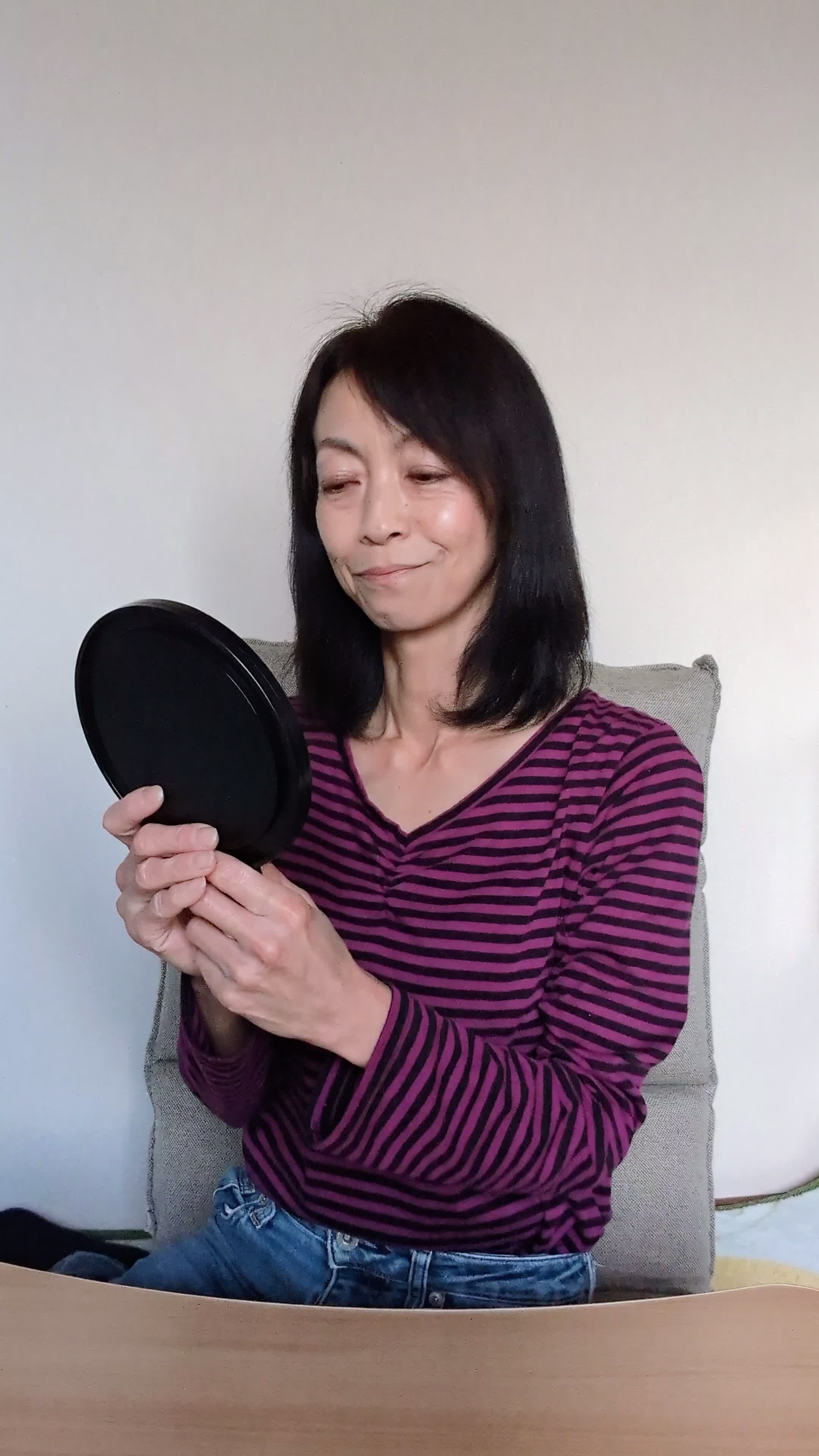 テーブルで鏡を見ながら、「体臭ケア後の自分に自信を持つ」満足げな表情