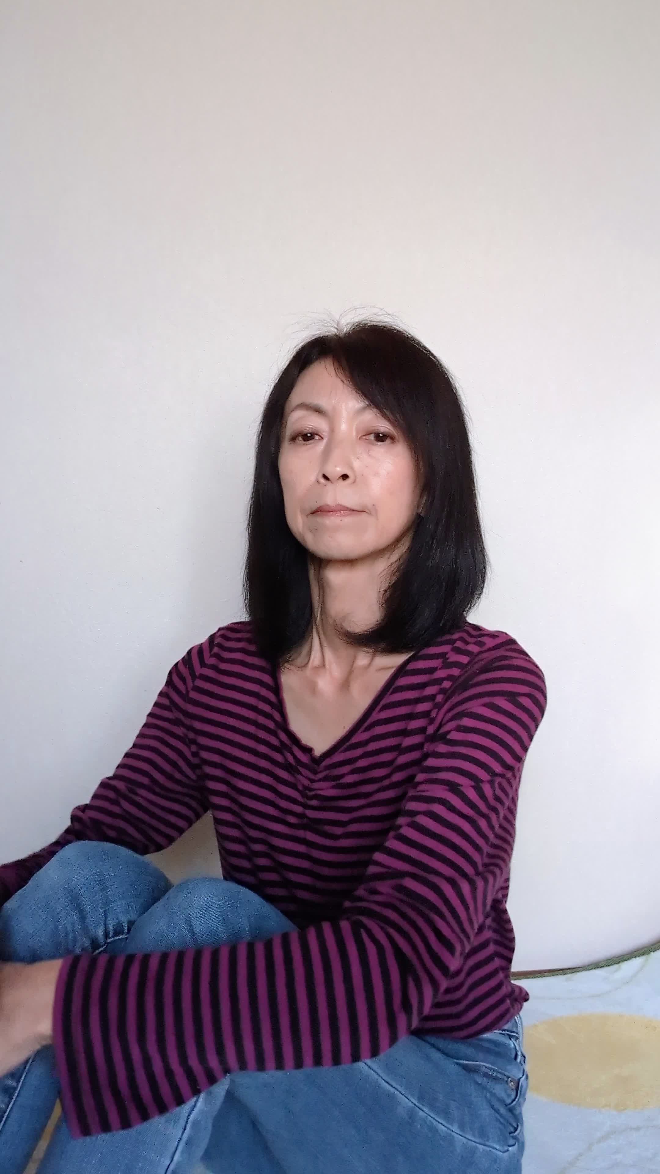 床で膝を抱え、「これが本当に効くのかな」と悩む様子