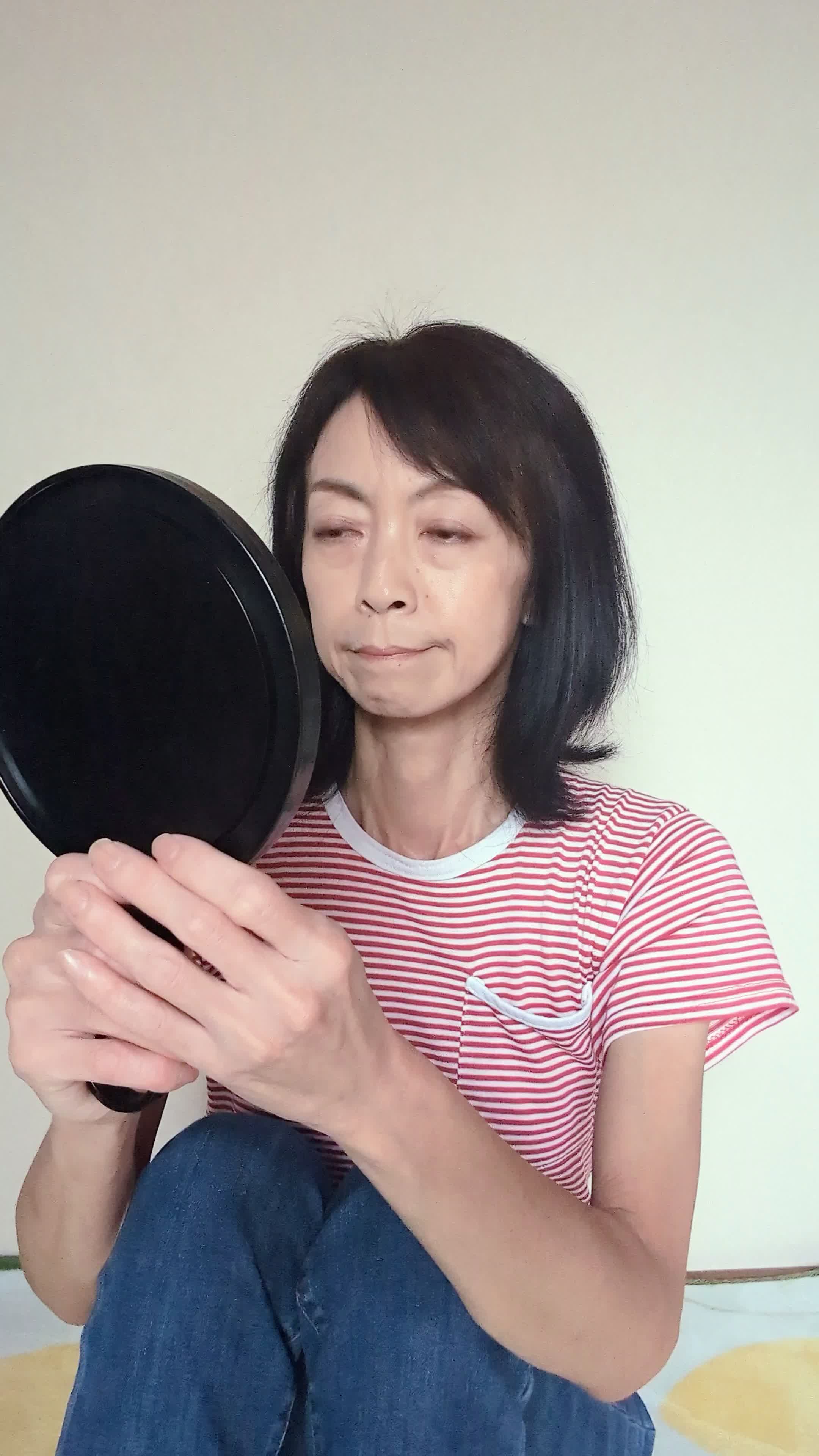床で白髪を手で隠して、「もっと若々しく見える方法を考える」動作