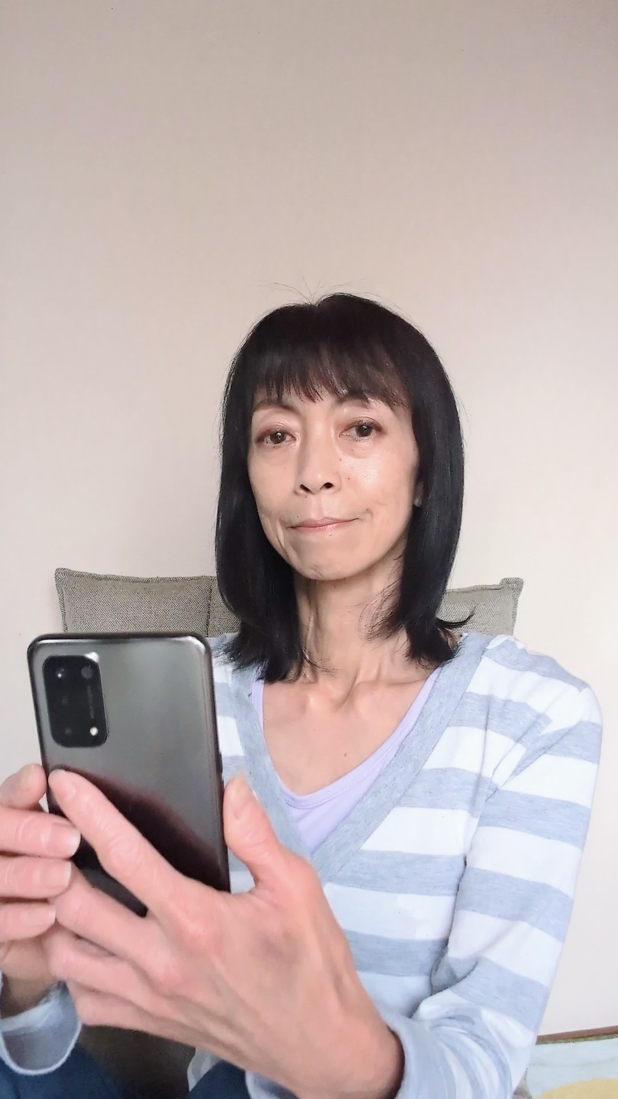椅子に腰掛け、「スマホの求人アプリを操作して理想の条件を探す」動作