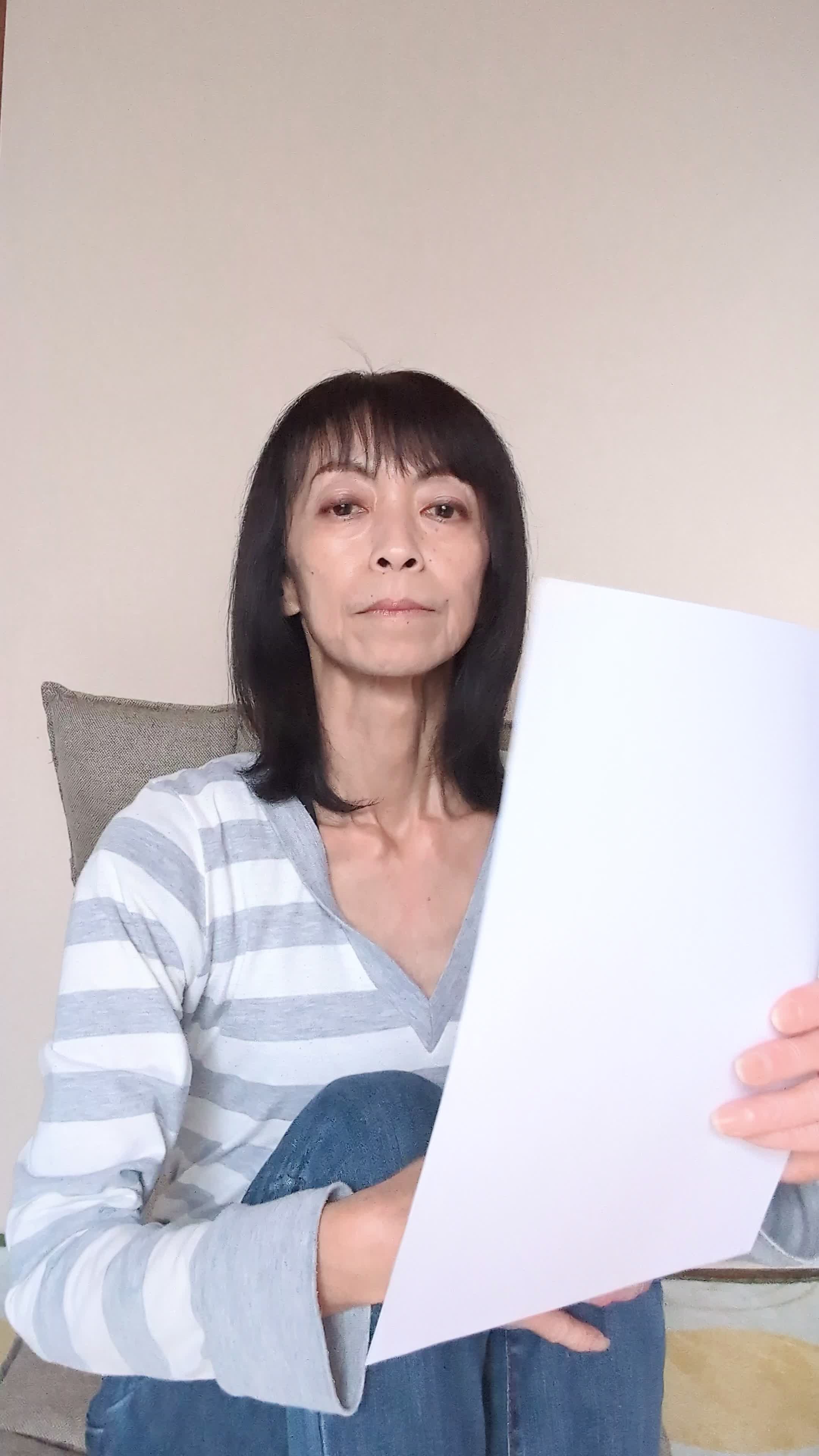ソファで膝を抱え、「応募書類をどう書こうか考える」真剣な様子