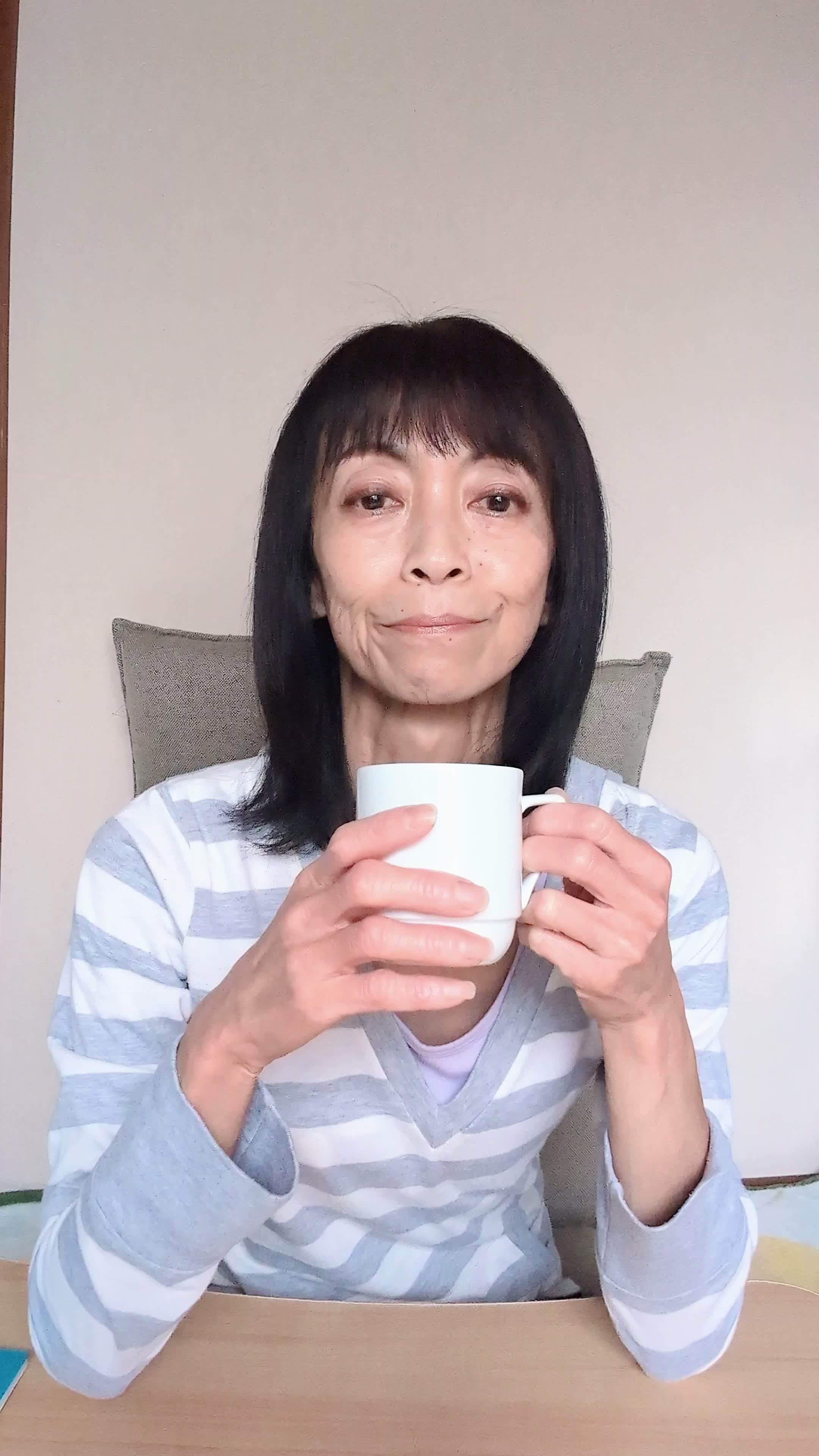 テーブルでカップを手に取り、「新しい仕事での生活を計画する」姿