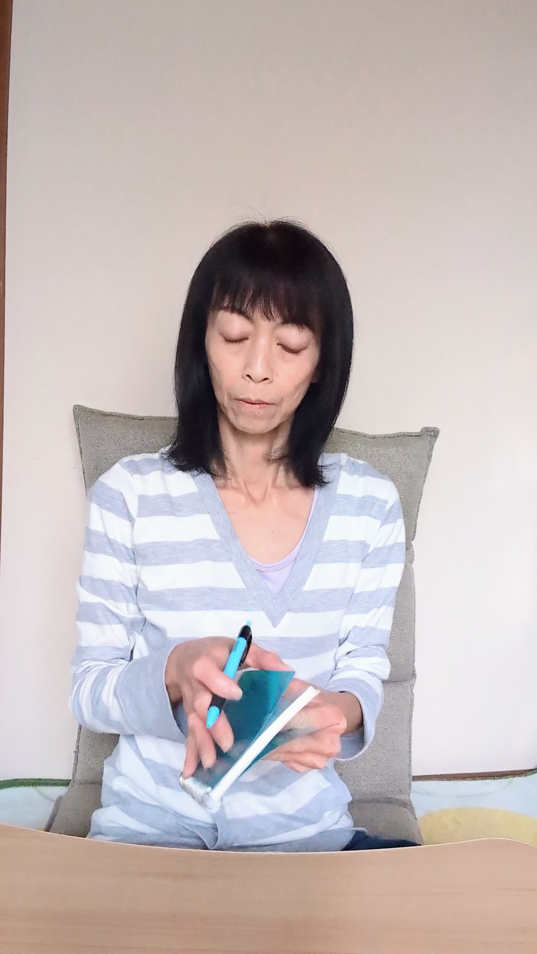 テーブルで手帳を開き、「応募の締め切りを確認する」集中した姿