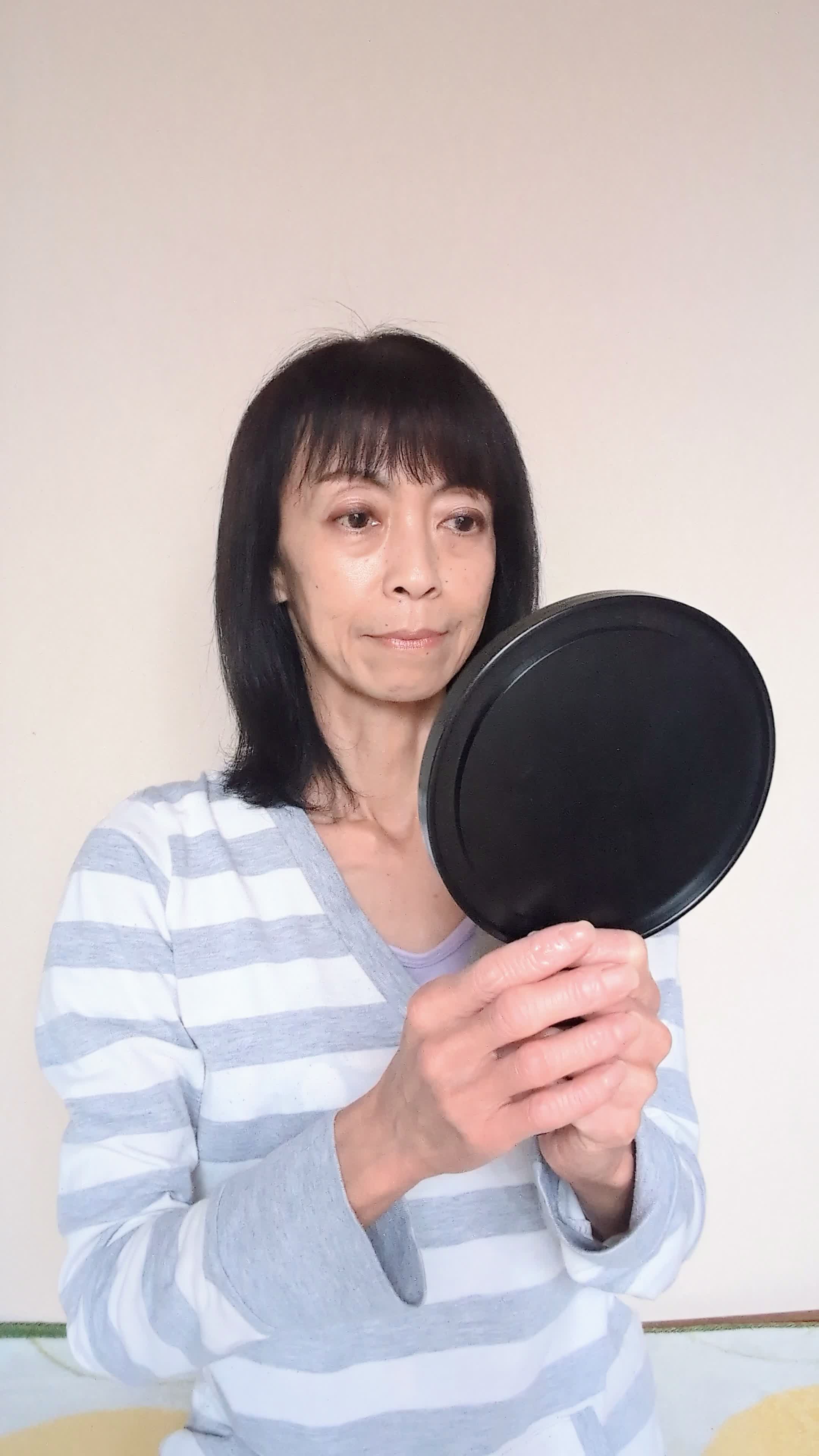 床で鏡を見ながら、「自己紹介の練習をする」集中した様子