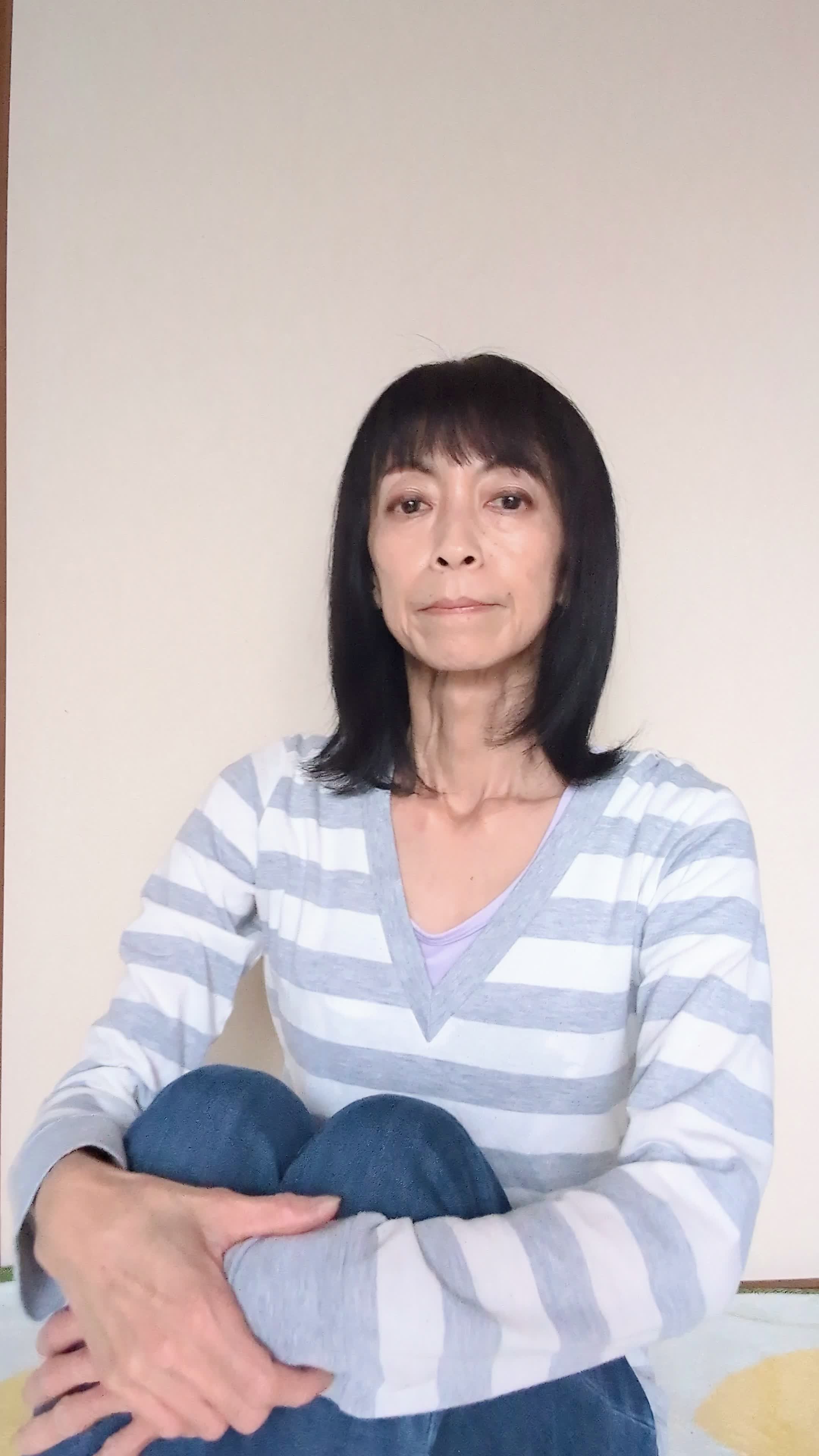 床で膝を立てて座り、「自分に合う求人が見つかることを願う」真剣な表情