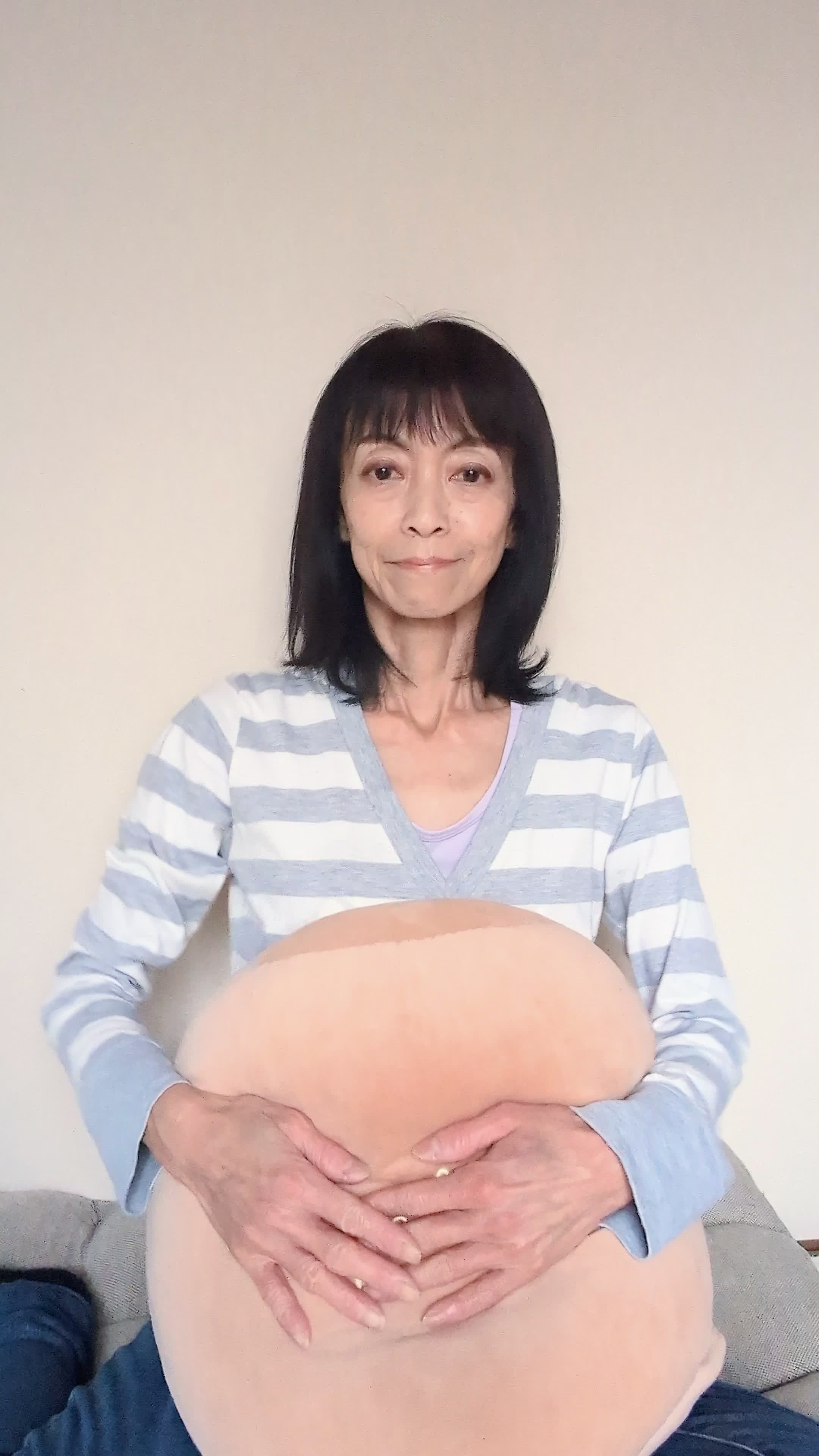 ベッドでクッションを抱え、「新しいチャレンジにワクワクする」様子