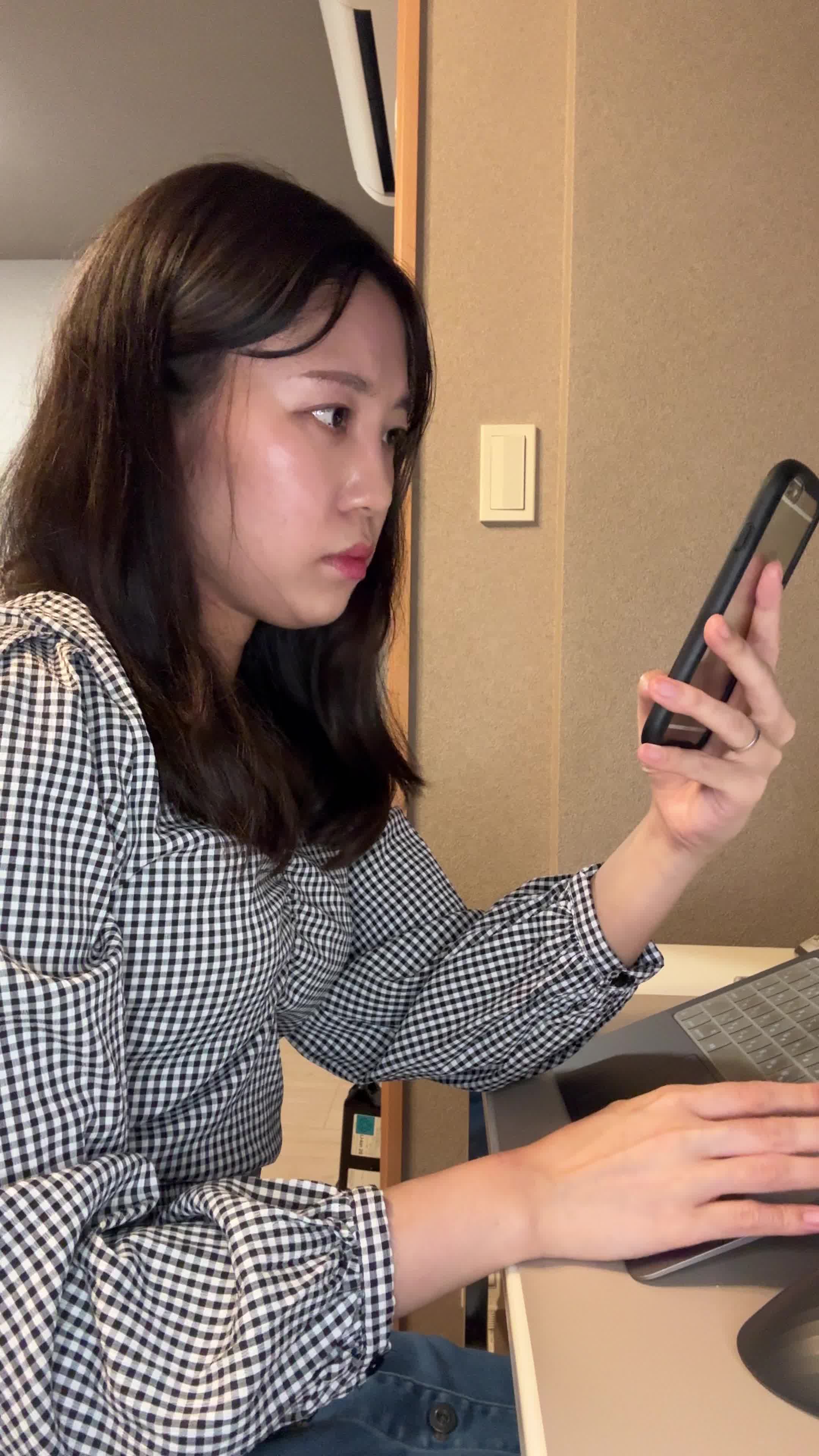 テーブルでスマホを操作しながら、「白髪ケアの商品を調べる」集中した表情