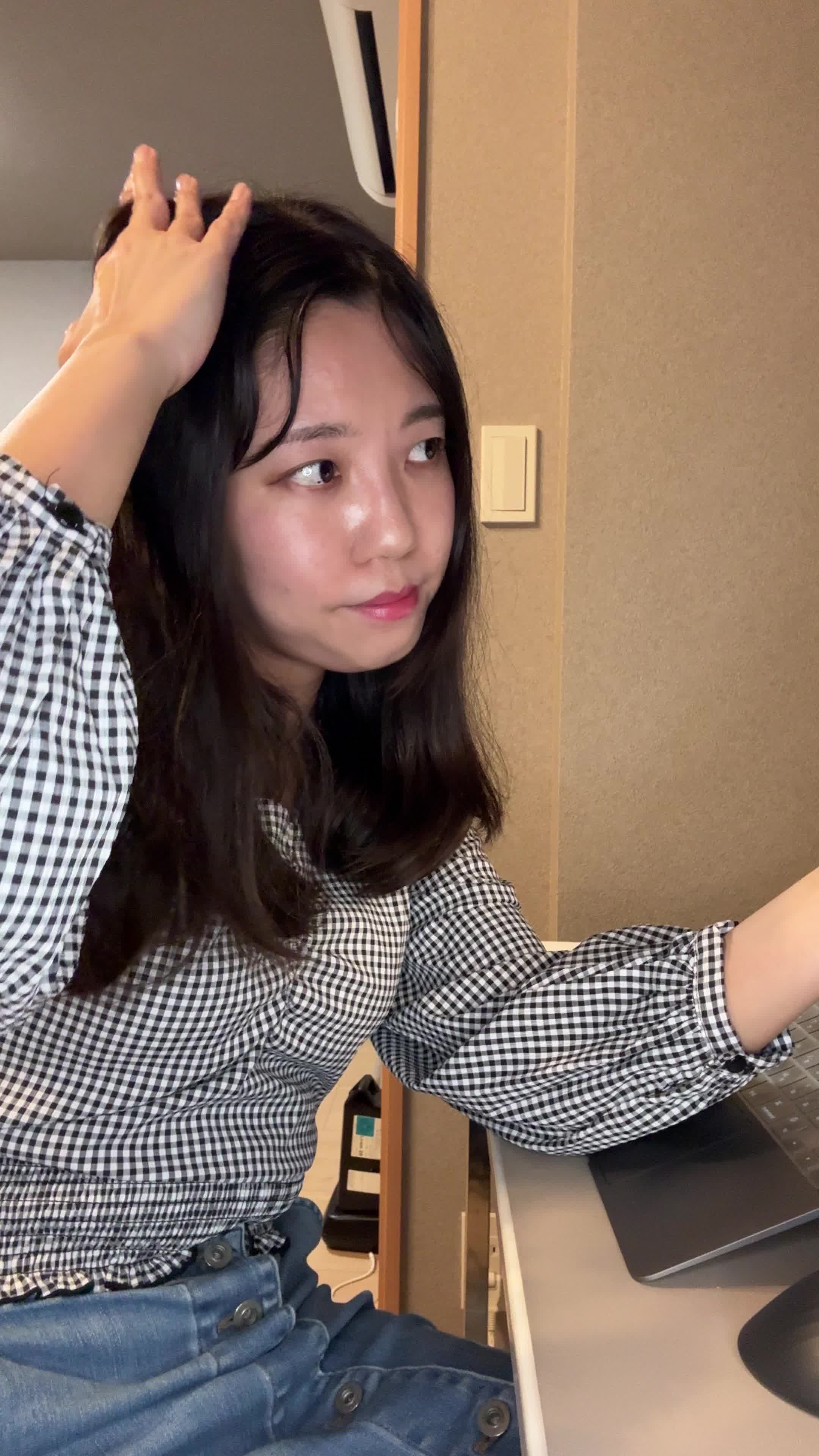 テーブルで髪を手に取り、「白髪部分をどうケアしよう」と計画する真剣な表情