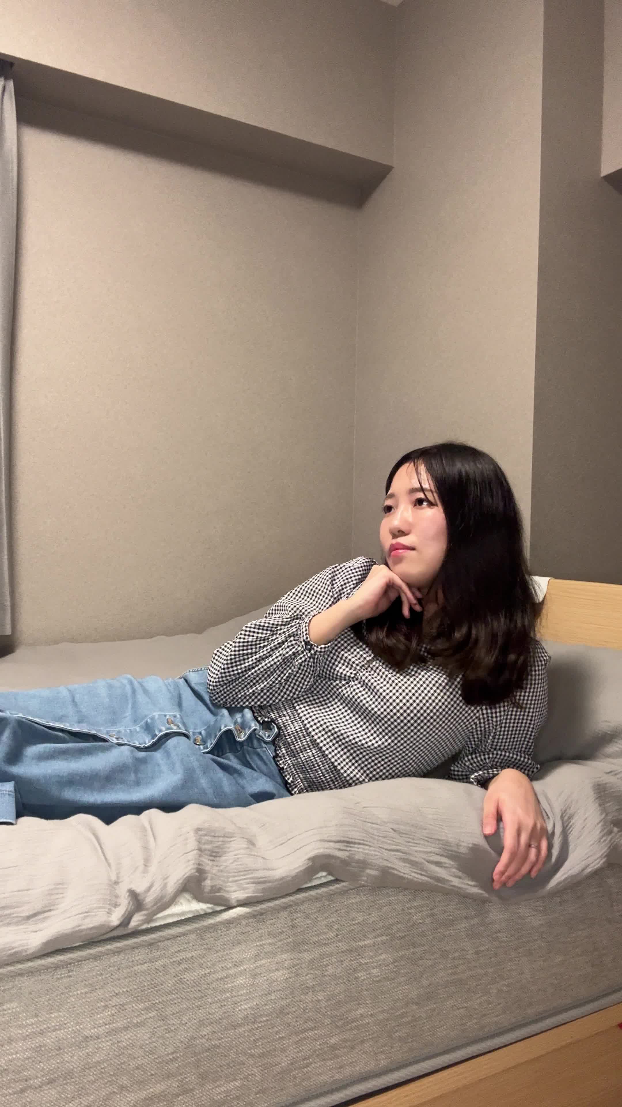 ベッドで横になり、「これ以上白髪が増えたらどうしよう」と不安そうに考える姿