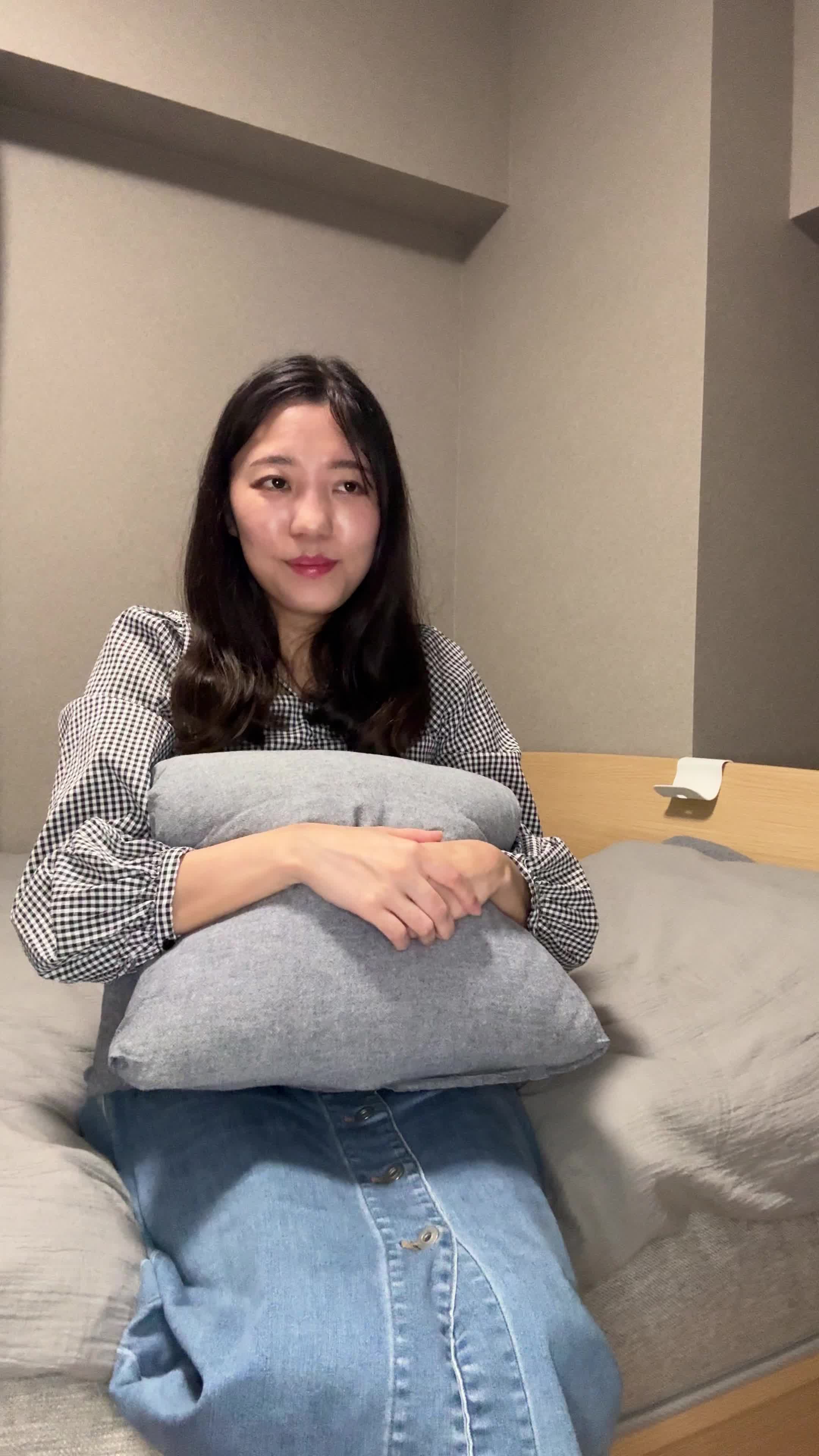 ベッドでクッションを抱えて、「白髪がなくなったらこんなことがしたい」と夢見る表情