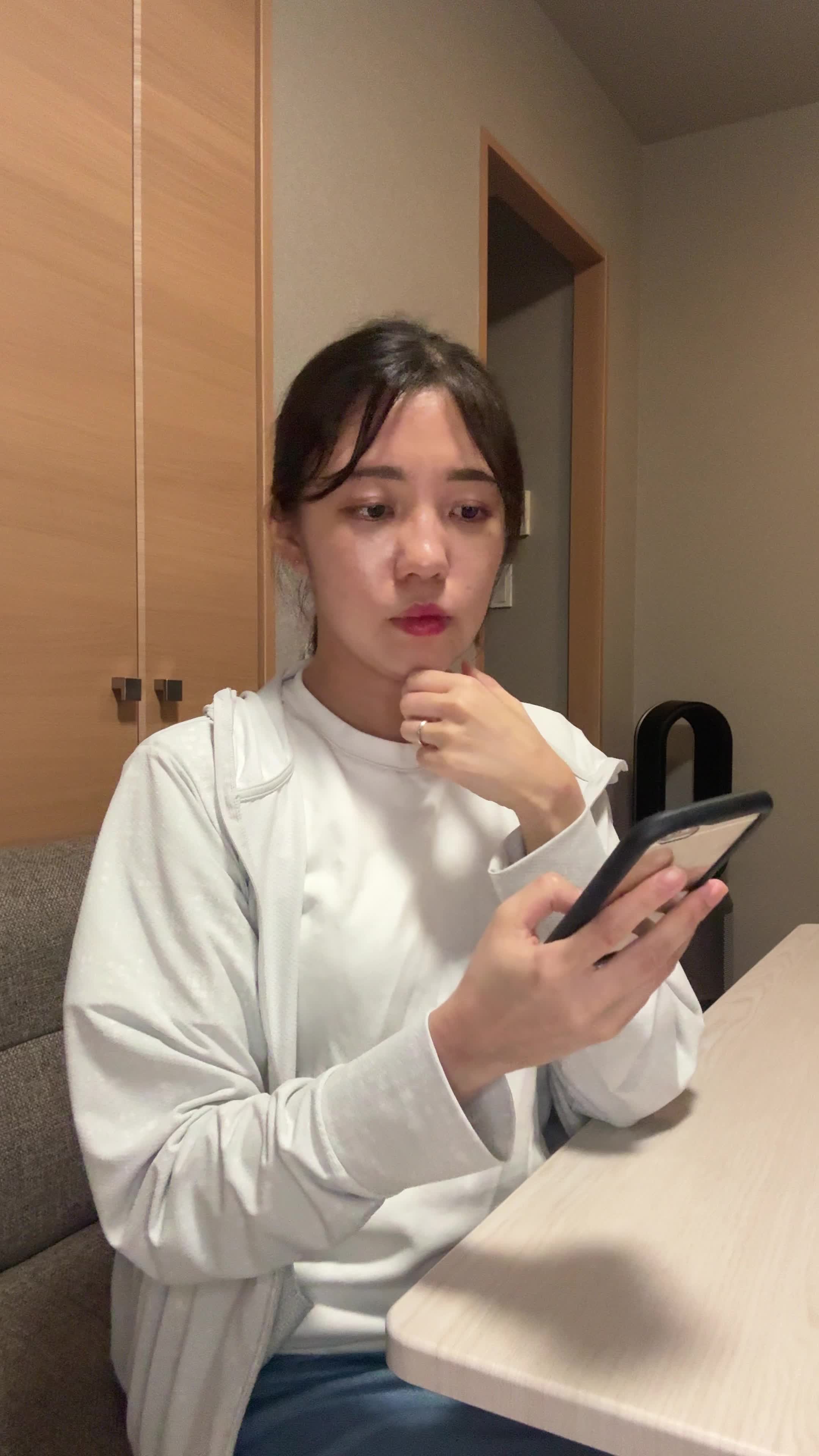 テーブルでスマホを操作しながら、「体臭ケアのおすすめ商品を調べる」集中した様子
