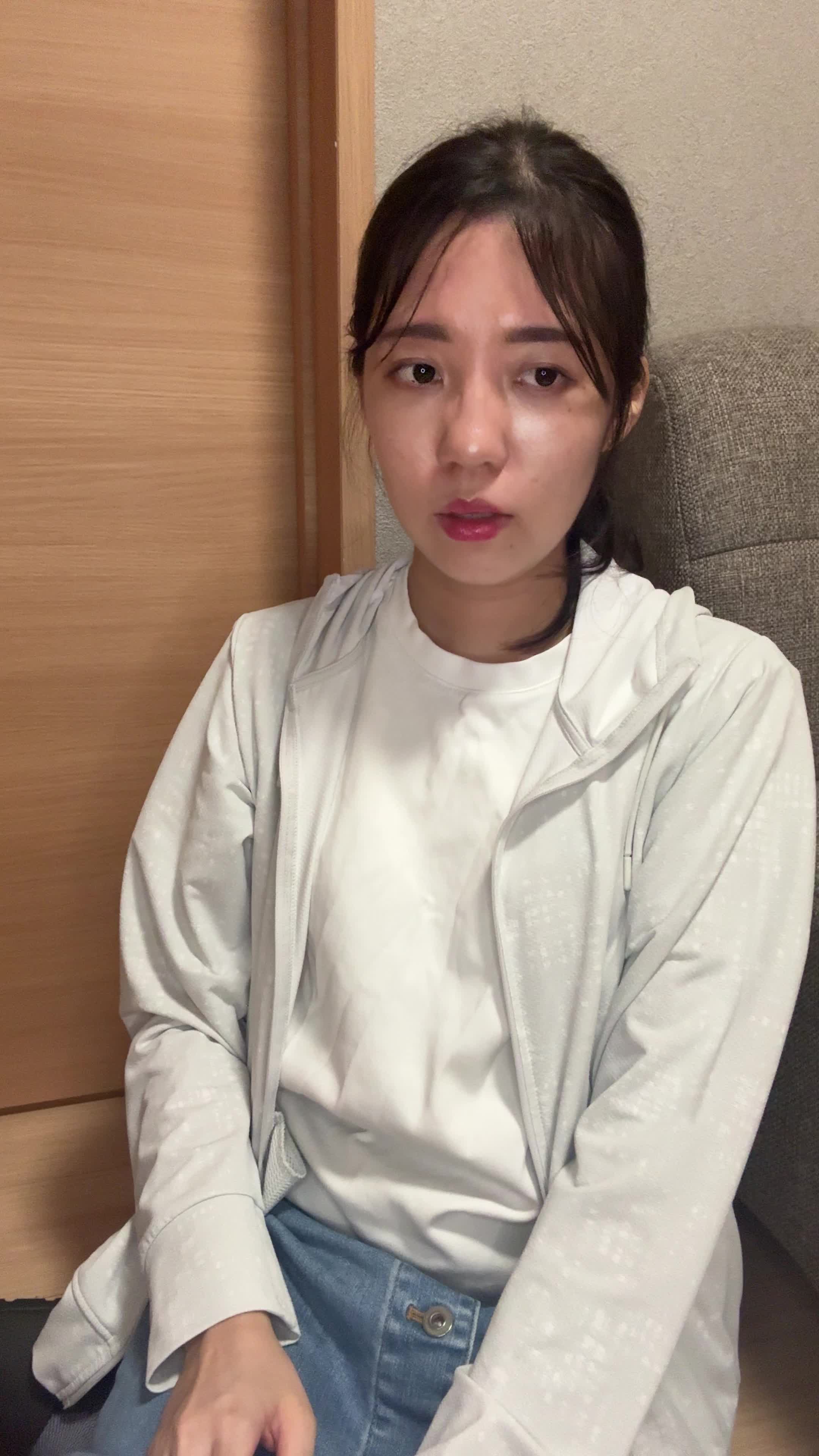 床に座り込み、自分のシャツを触りながら「このケアで変わるのかな」と考える仕草