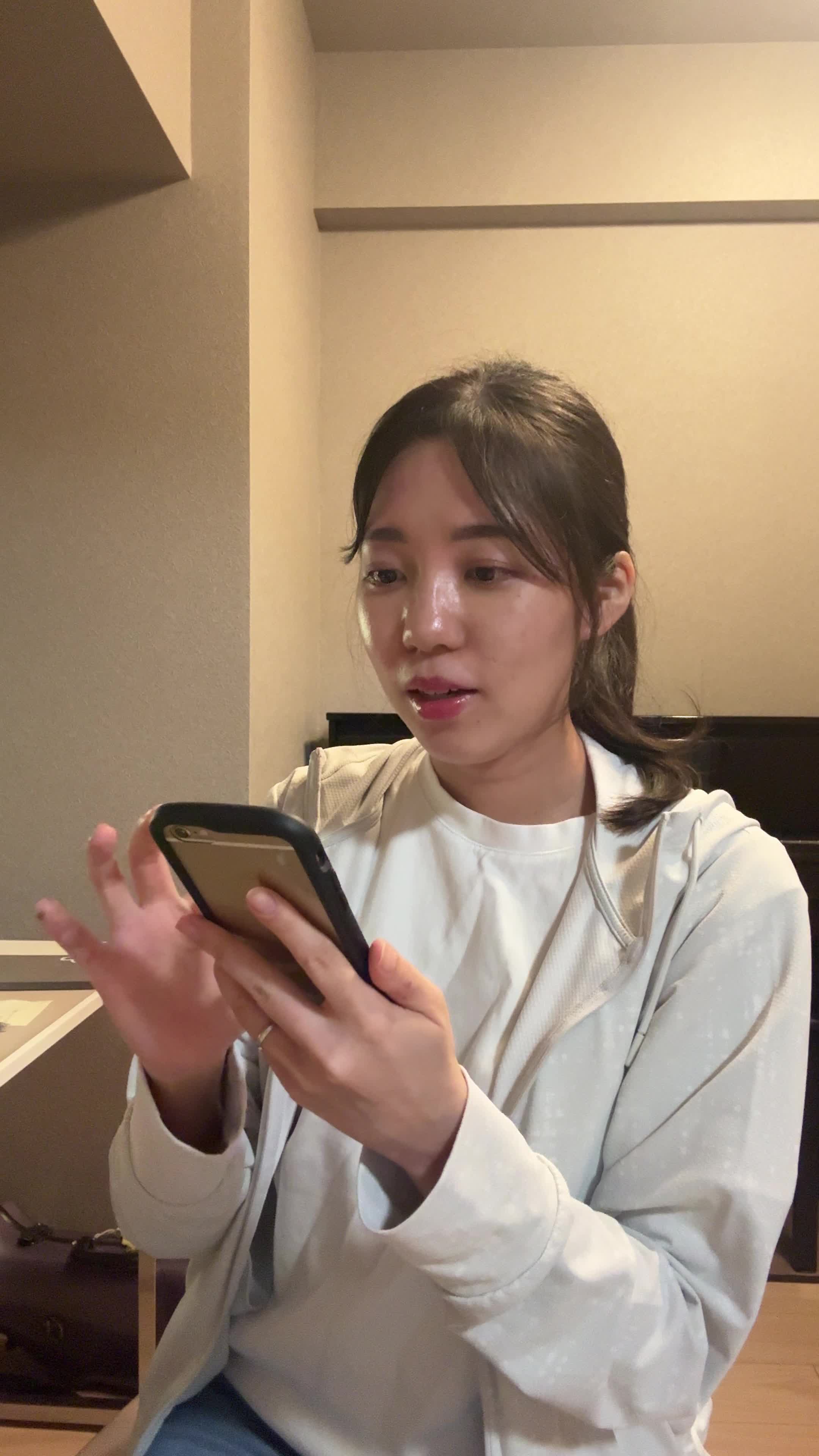 椅子に腰掛け、スマホの画面を見ながら「体臭ケアの口コミを読んで安心する」表情