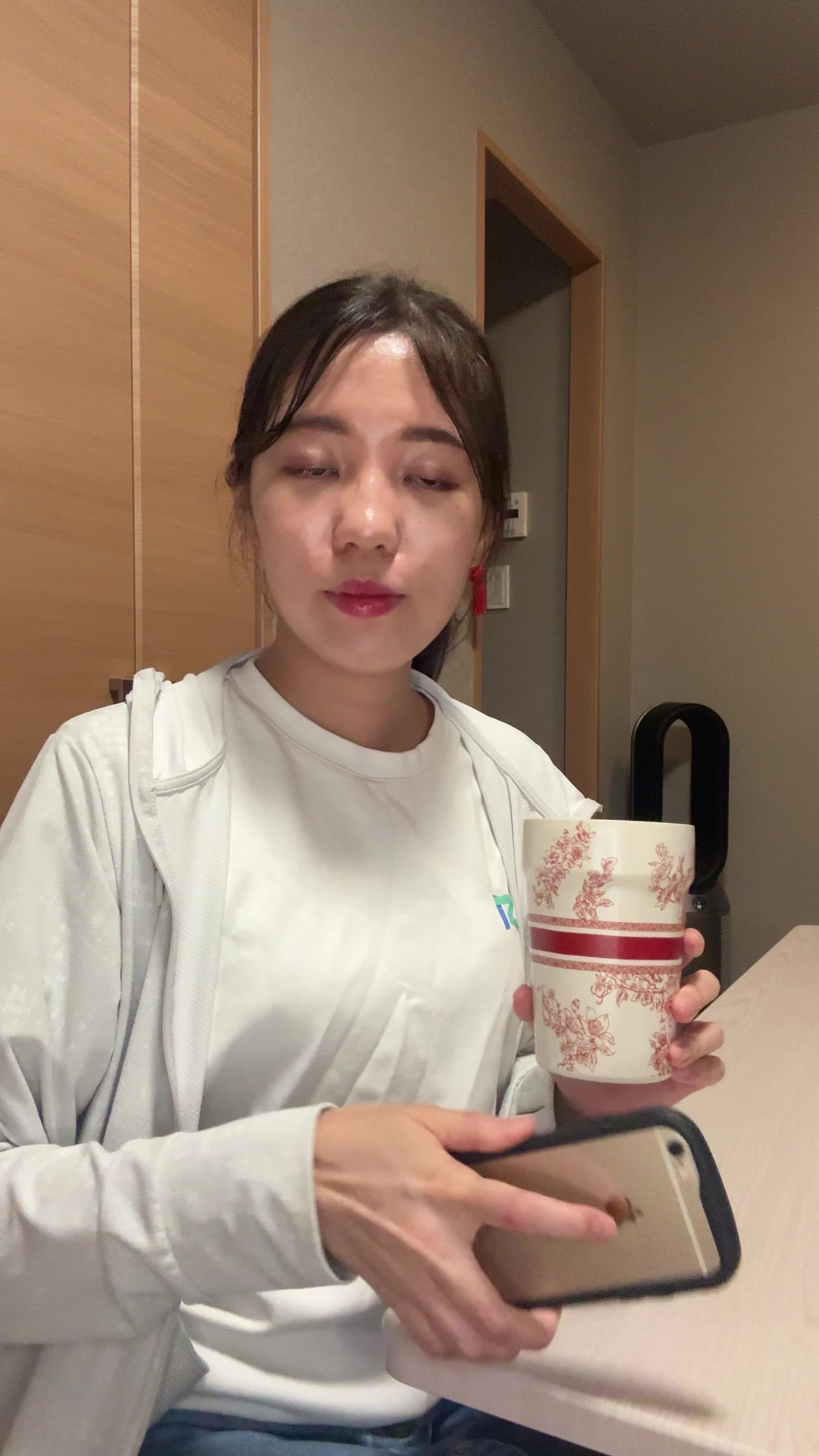 テーブルで水を飲みながら、「次の体臭ケアアイテムを選ぶ」リラックスした表情