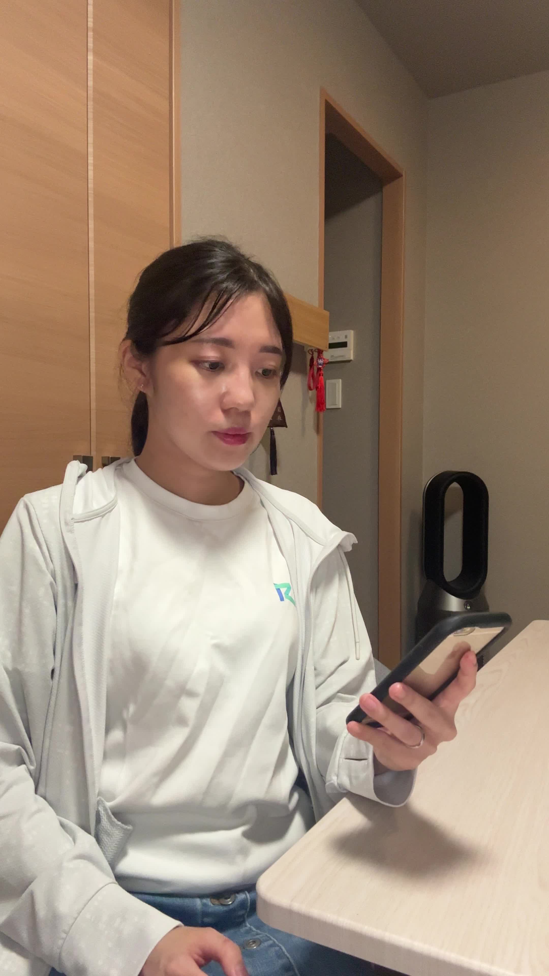 テーブルに置いたスマホを見ながら、「新しいケア方法を試す決意を固める」動作
