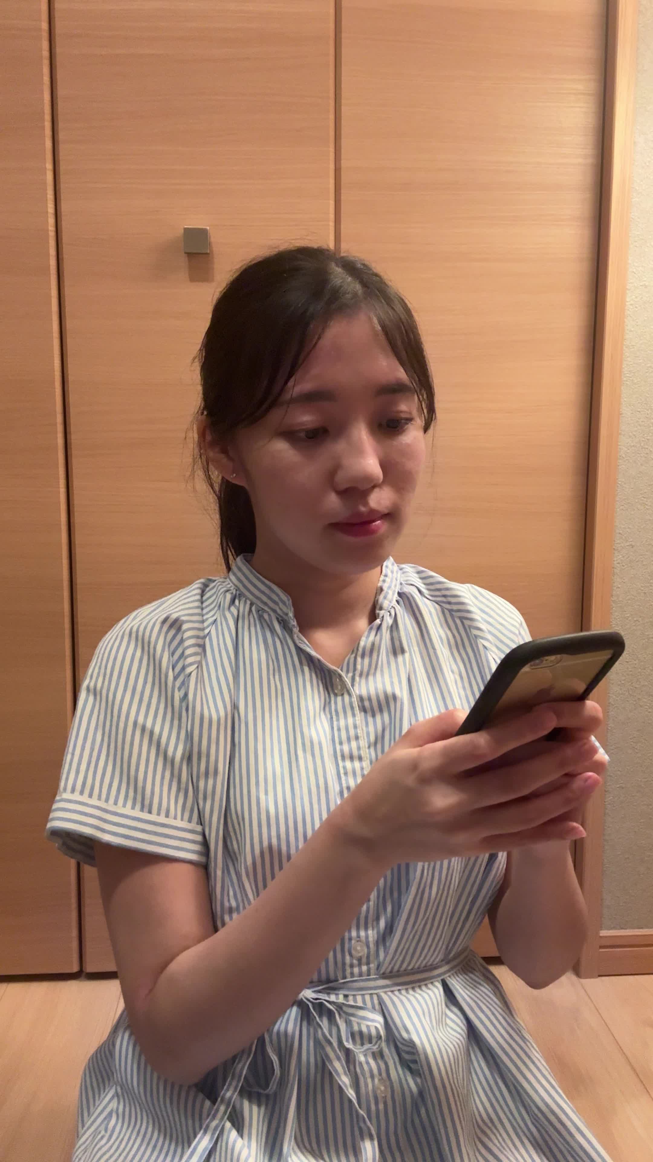 床に座り込み、「これなら挑戦できるかも」とスマホの画面を見て微笑む姿