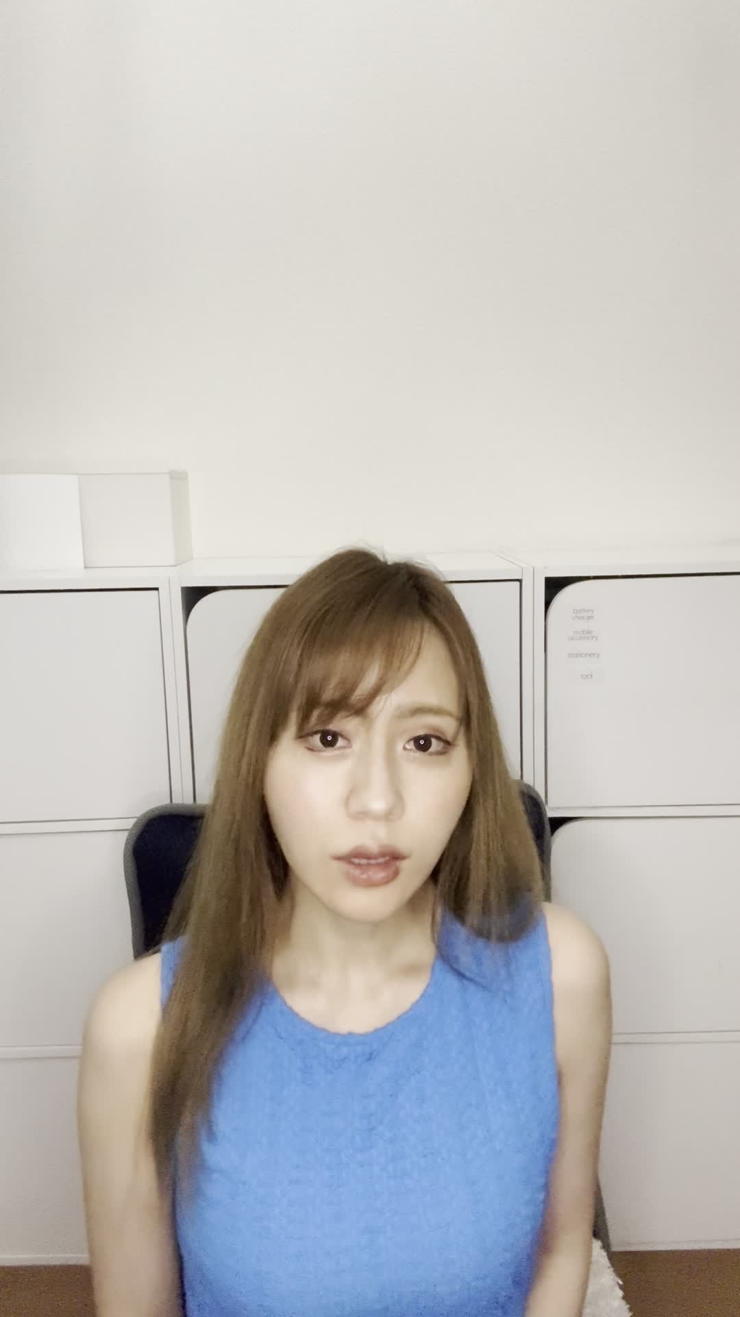 ソファで友達と話しながら、「自分の歯並びが気になる」と口元を隠す仕草
