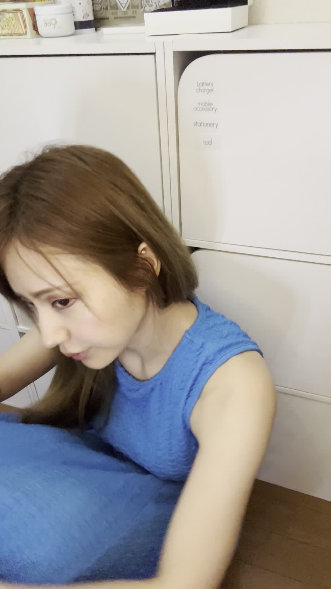 床で膝を抱え、「笑顔にもっと自信が持てるようになりたい」と考え込む様子