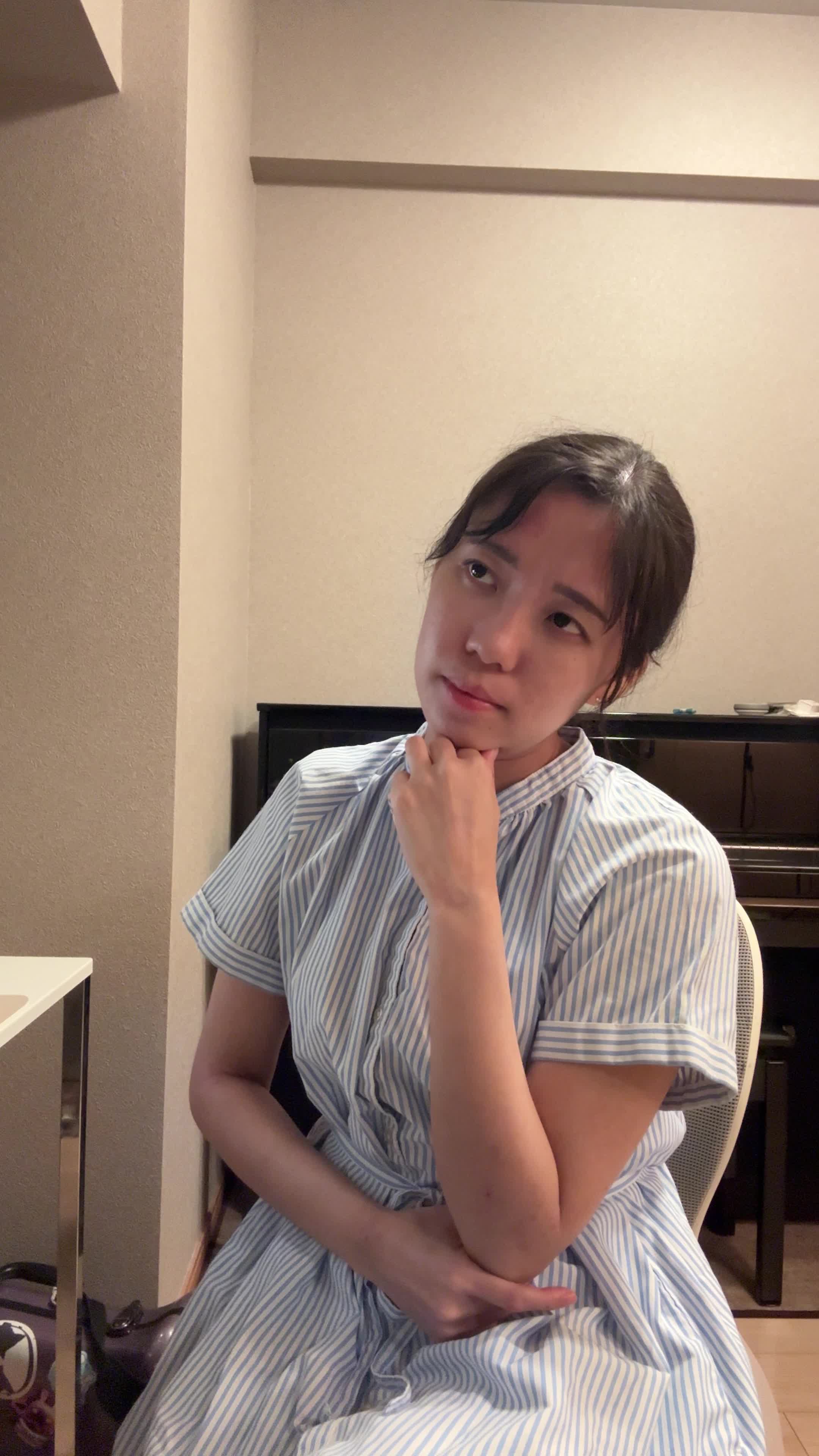 椅子に浅く腰掛け、「腸活サプリメントを試すべきか迷う」悩ましげな表情